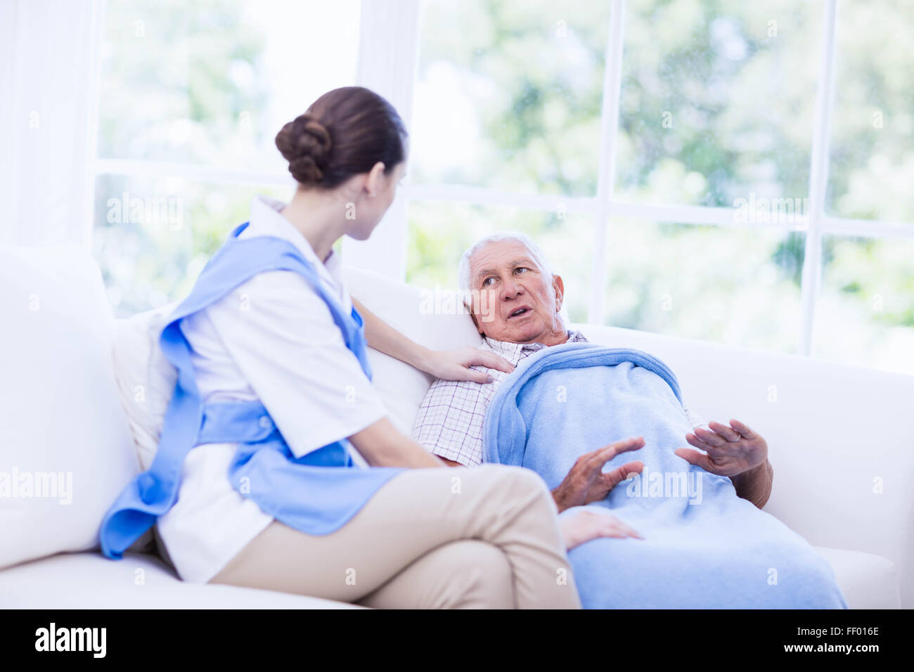 Krankenschwester kümmert sich um kranke ältere Patienten Stockfoto