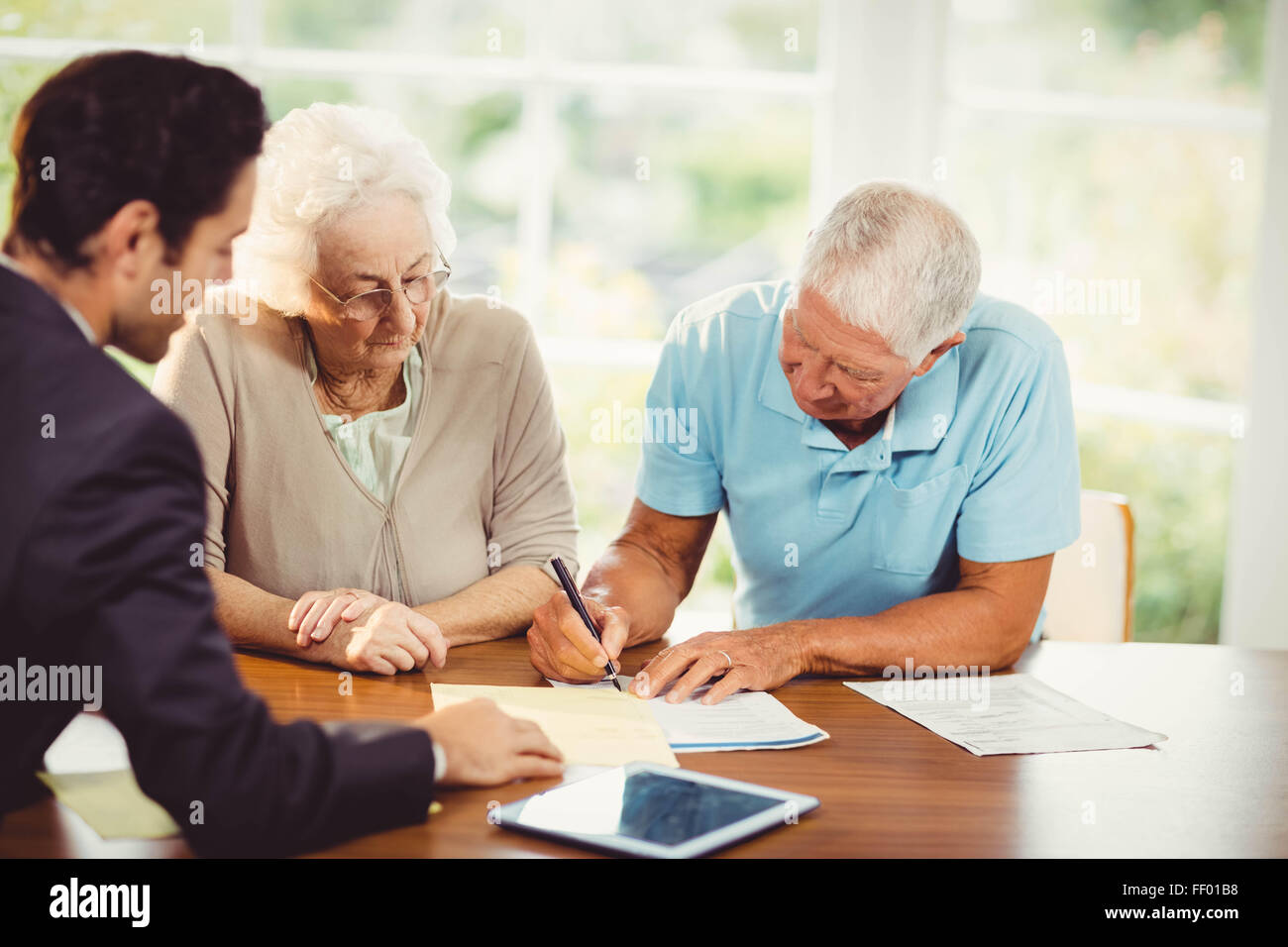 Älterer mann Unterzeichnung Dokument Stockfoto