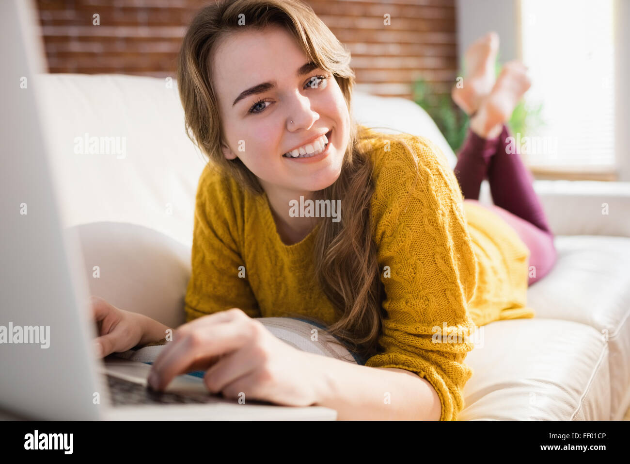 Lächelnde hübsche Frau mit laptop Stockfoto