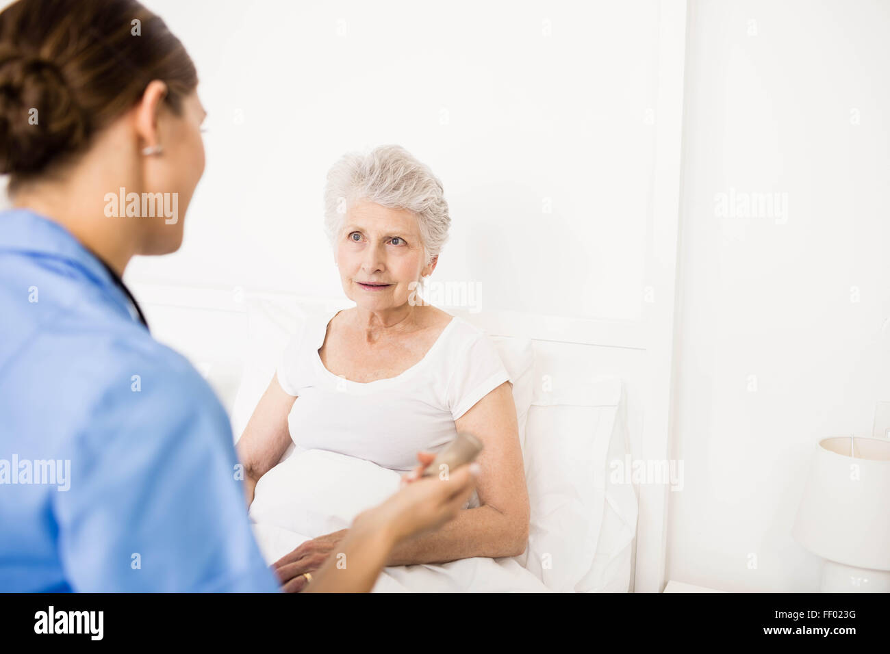 Krankenschwester kümmert sich um die leidenden älteren Patienten Stockfoto