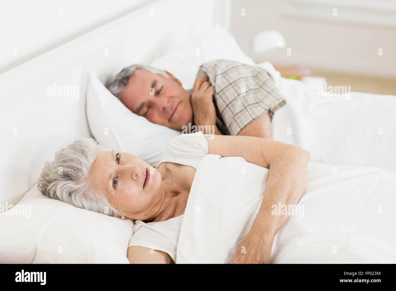 Reife Frau wach im Bett Stockfoto