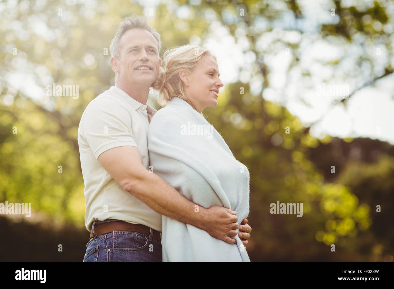 Mann umarmt seine Frau in eine Decke Stockfoto