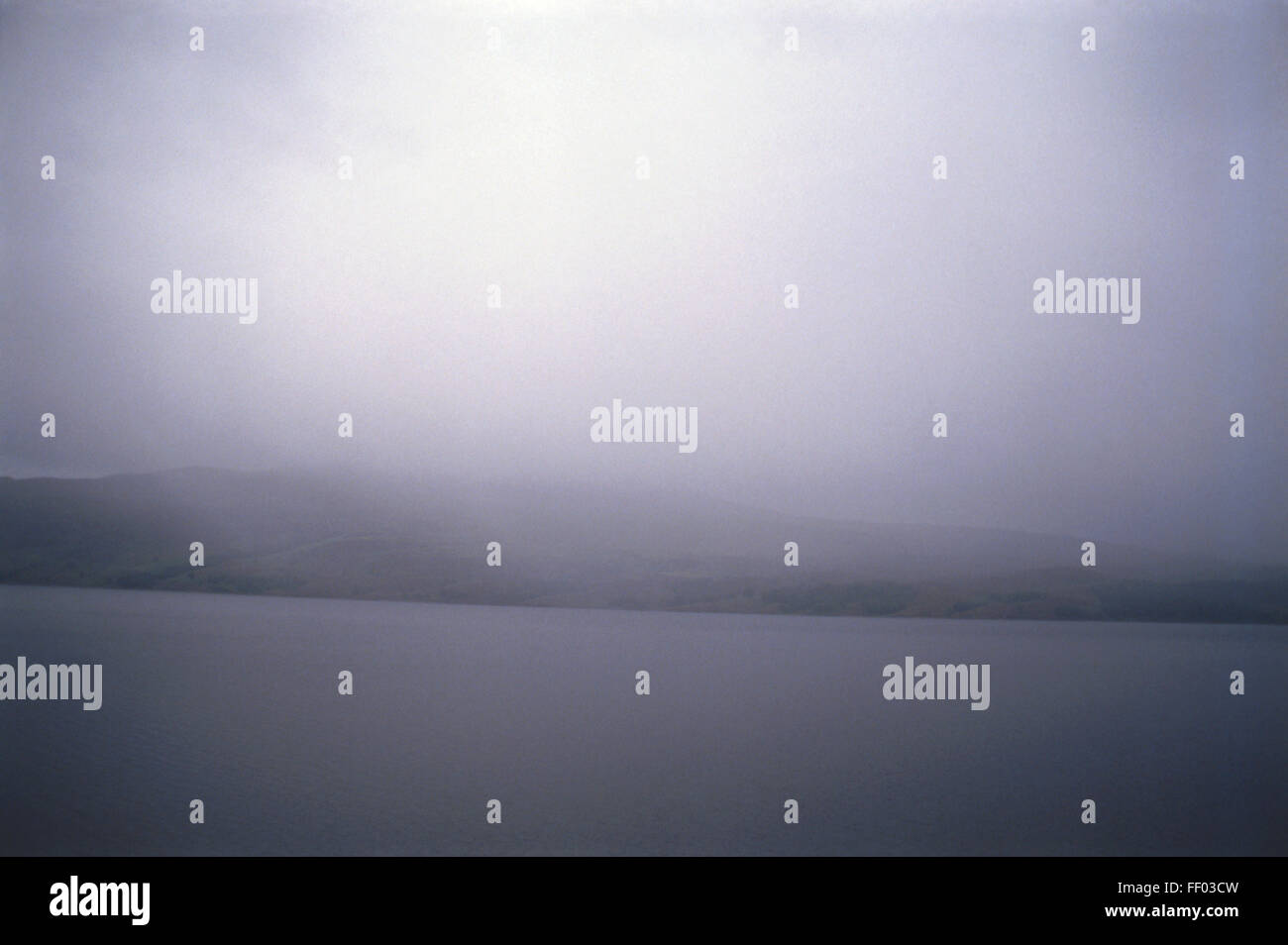 Küsten Stratus, graue Wolke Layer Himmel bedeckend, grünen Klippe hüllt, düsteren Licht über graue Meer wirft. Stockfoto