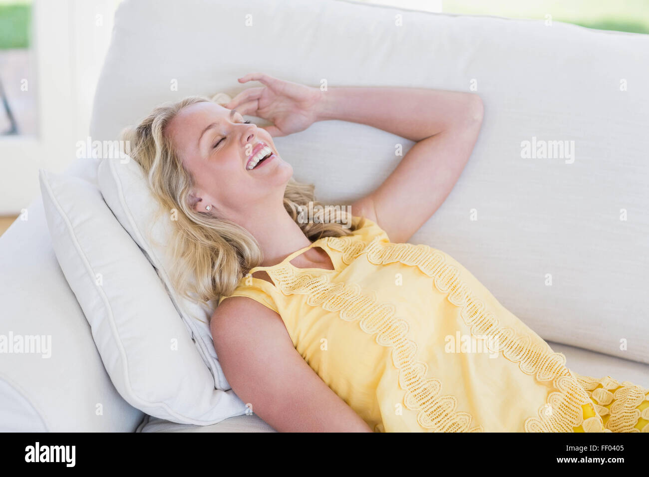 Glückliche Frau entspannend auf sofa Stockfoto