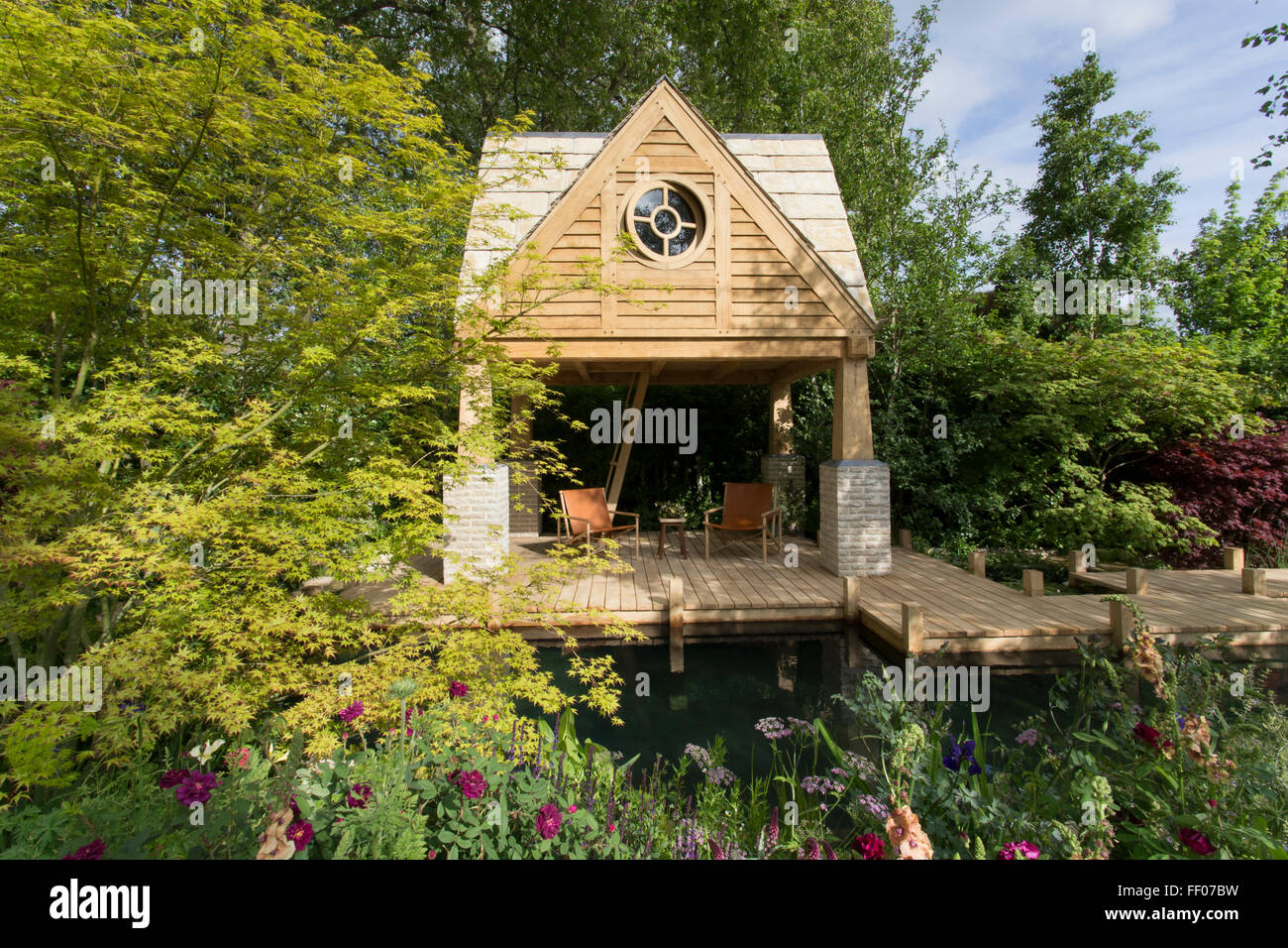 The M & G Garden The Retreat - Sommerhaus aus Eichenholz mit Holzsteg über natürlichem Swimmingpool - Wildteich Schwimmen - Chelsea Flower Show - England Großbritannien Stockfoto
