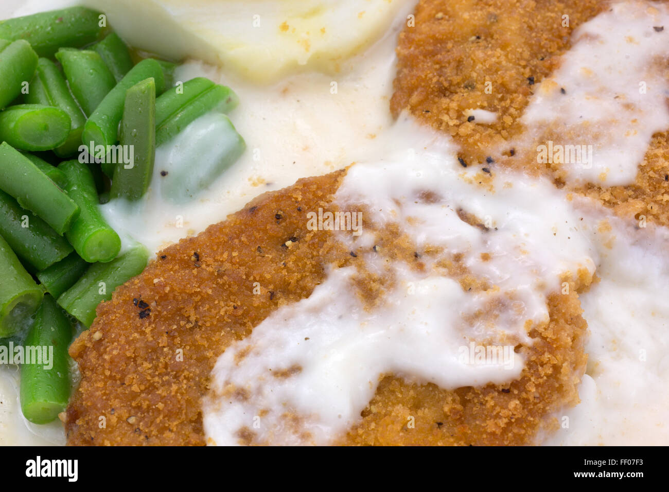 Nahaufnahme einer Mikrowelle Brathähnchen Bratlinge Soße TV Dinner mit Kartoffelpüree und grünen Bohnen. Stockfoto