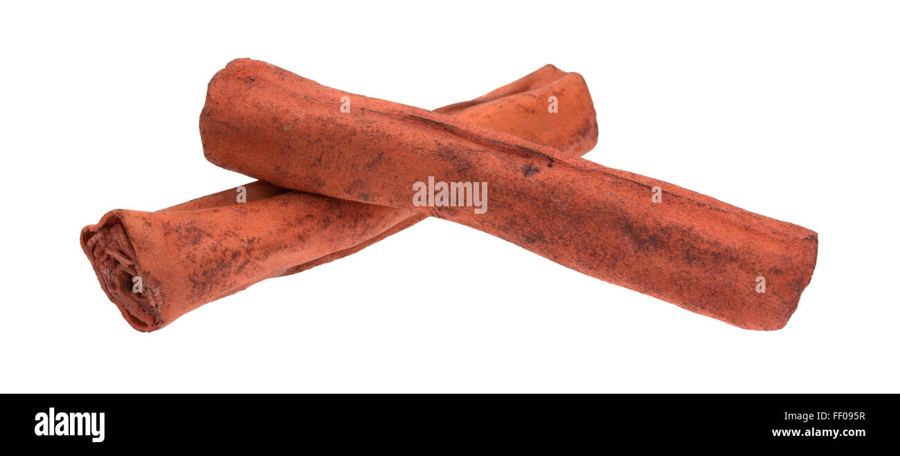 Seitenansicht von zwei gefärbten roten Rohhaut Fetch sticks für Hunde isoliert auf einem weißen Hintergrund. Stockfoto