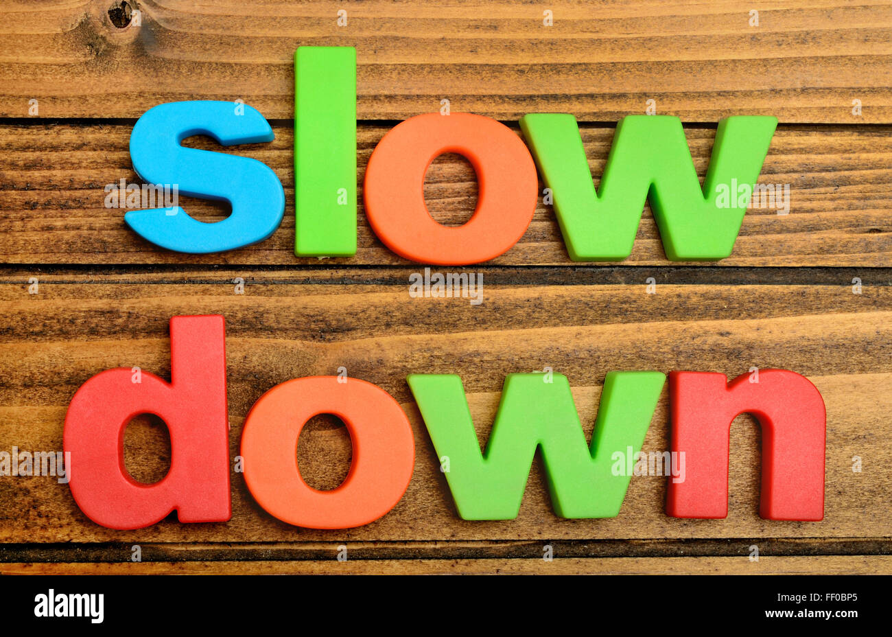 Slow Down Wort auf Holztisch Stockfoto