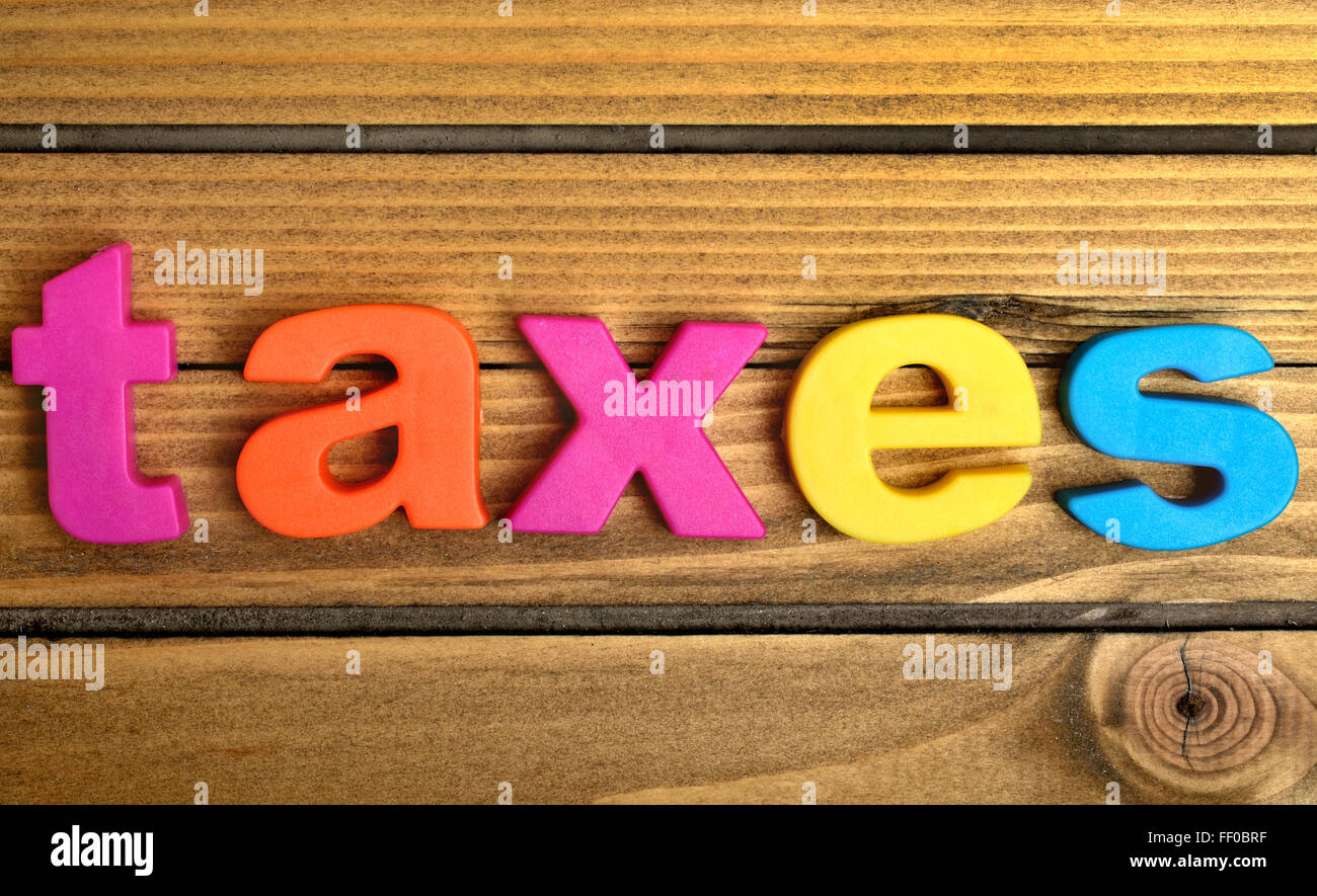 Steuern-Wort auf Holztisch Stockfoto