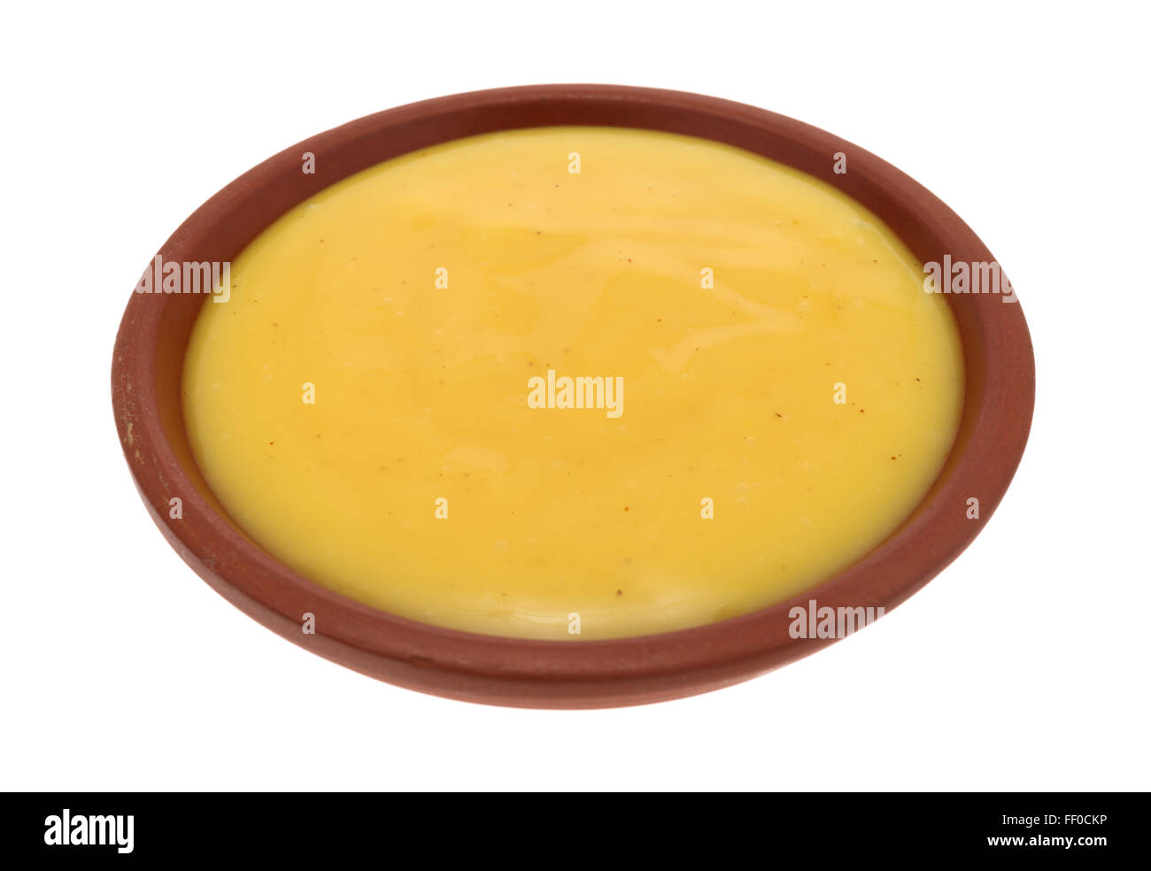 Seitlicher Blick auf eine kleine Schüssel mit Honig-Senf Salatdressing isoliert auf einem weißen Hintergrund. Stockfoto
