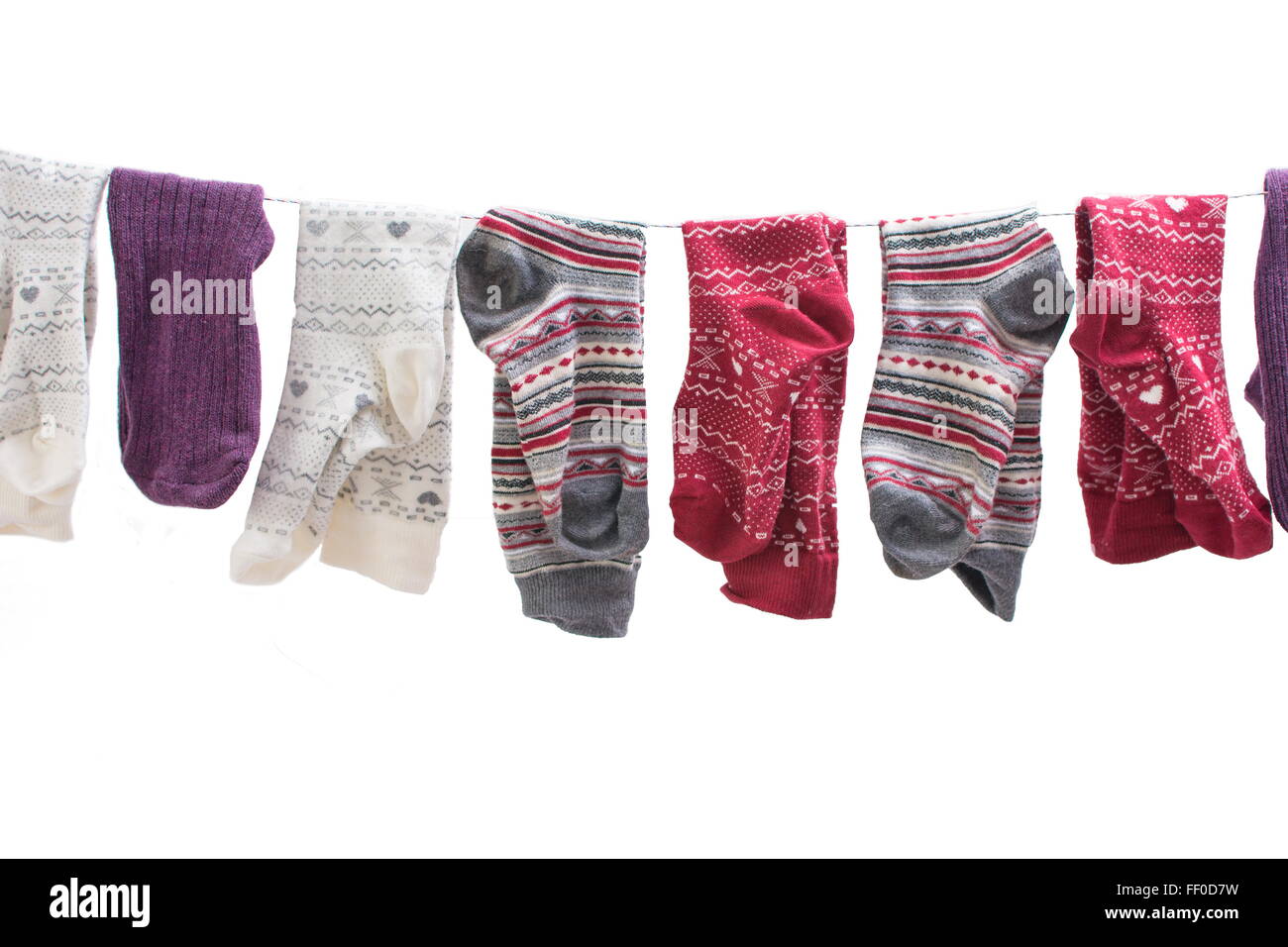 Verschiedene farbige Socken hängen an einem Draht Stockfoto