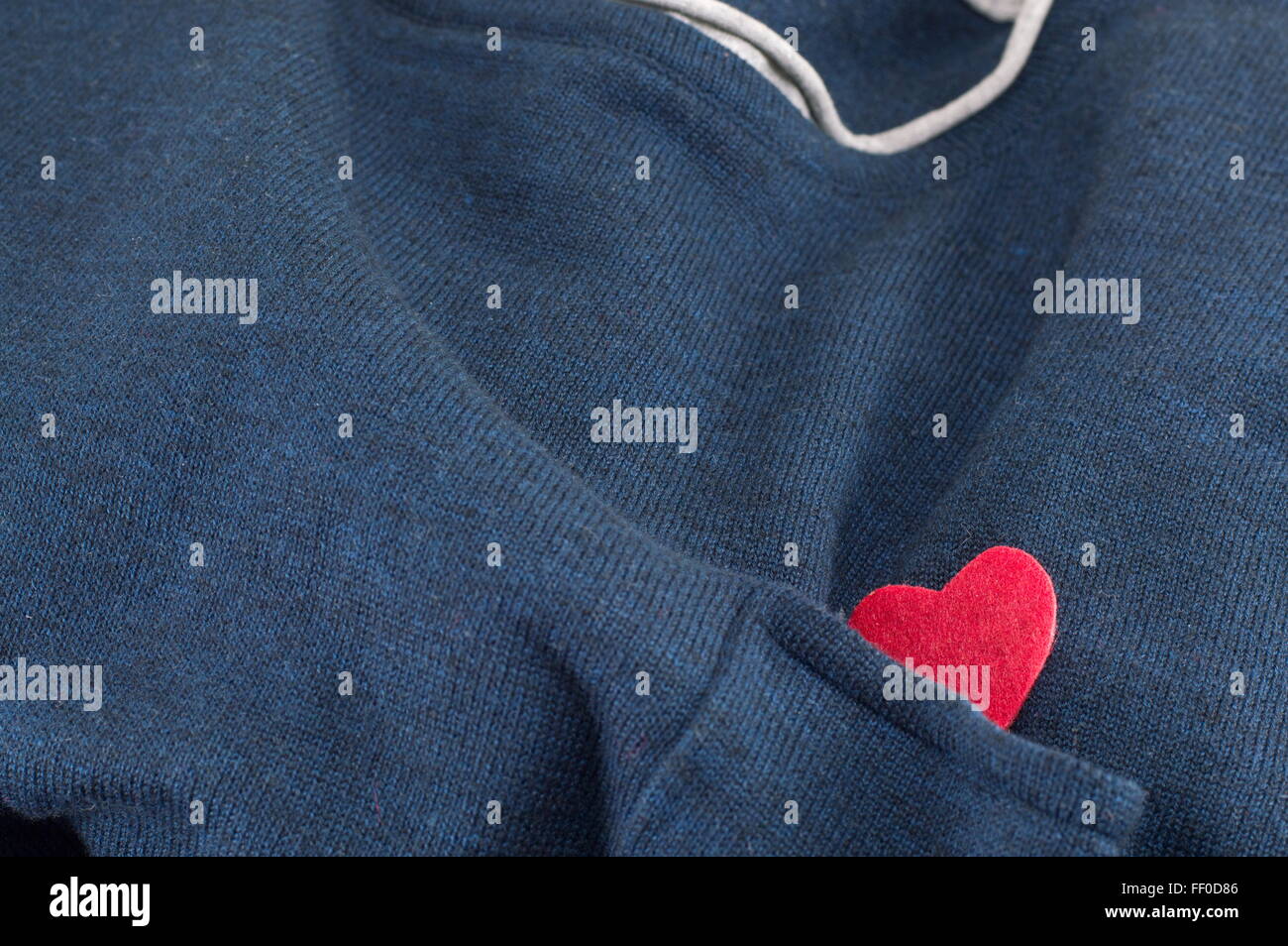 blauen Pullover mit einem Herz mit dem Ärmel versteckt Stockfoto