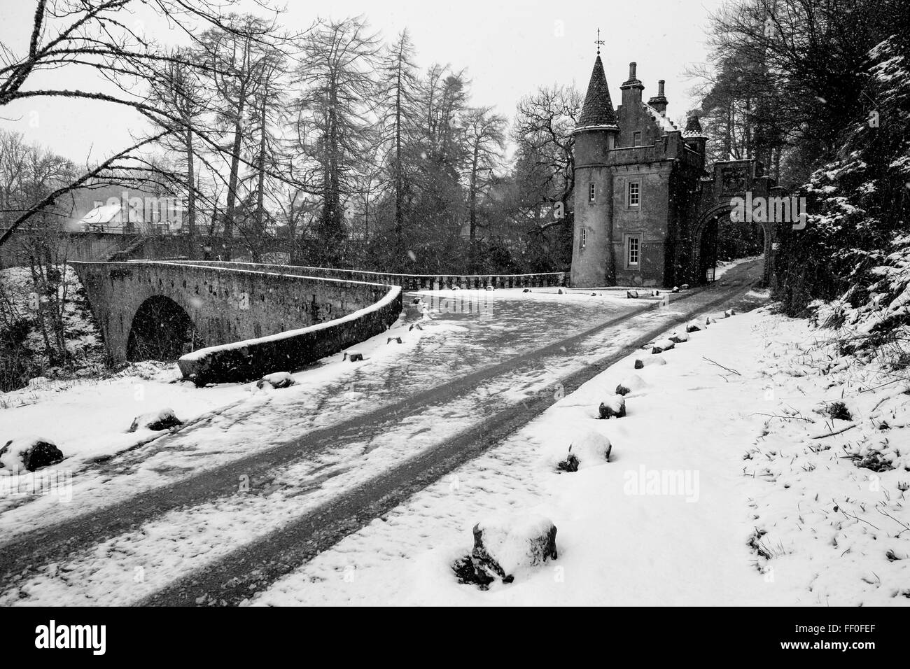 Gate House Torhaus einer schönen Burg am Ufer des Flusses Spey während eines Schneesturms. Stockfoto