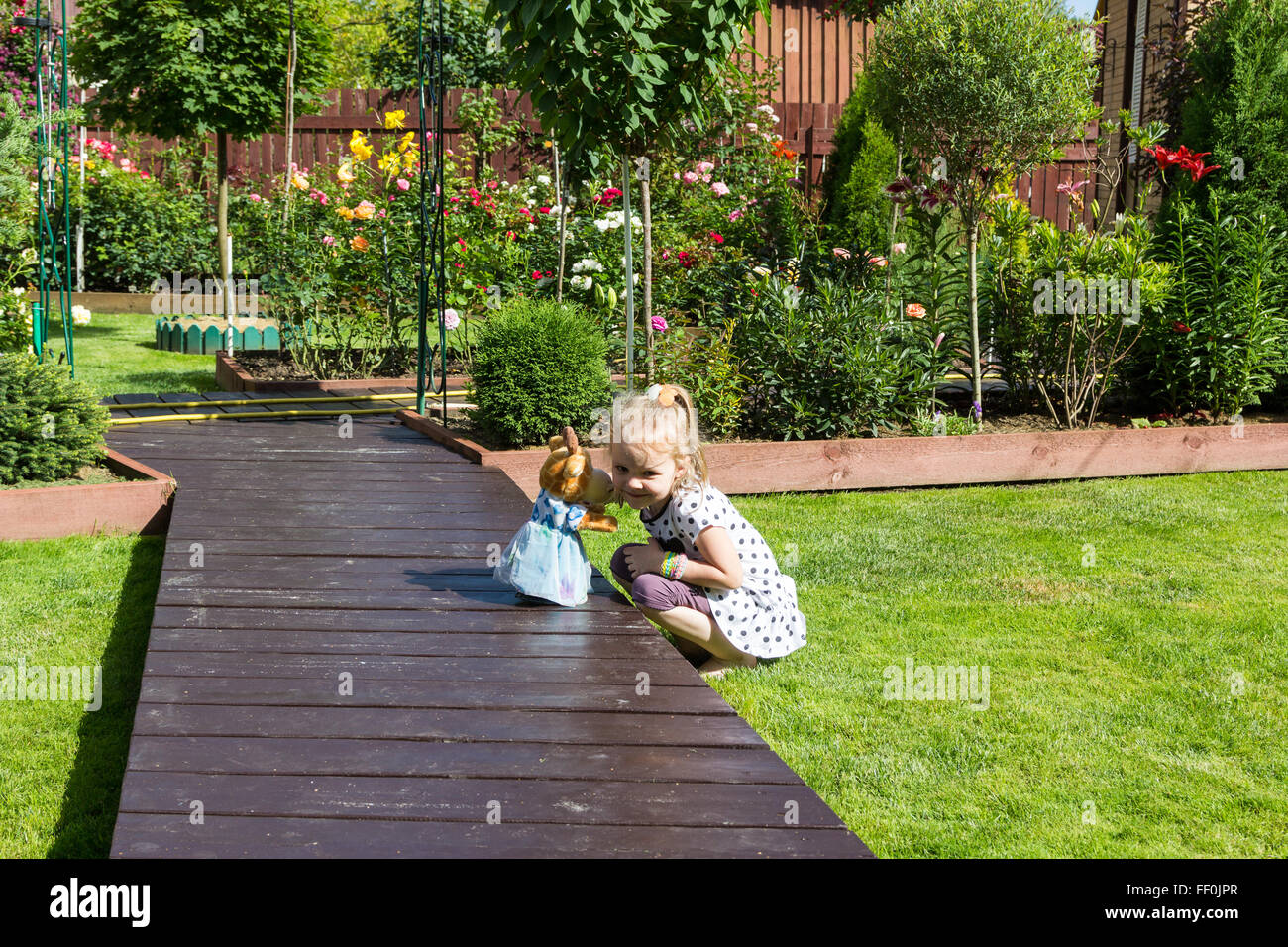 Mädchen spielen auf Rasen in einem schönen Garten Stockfoto
