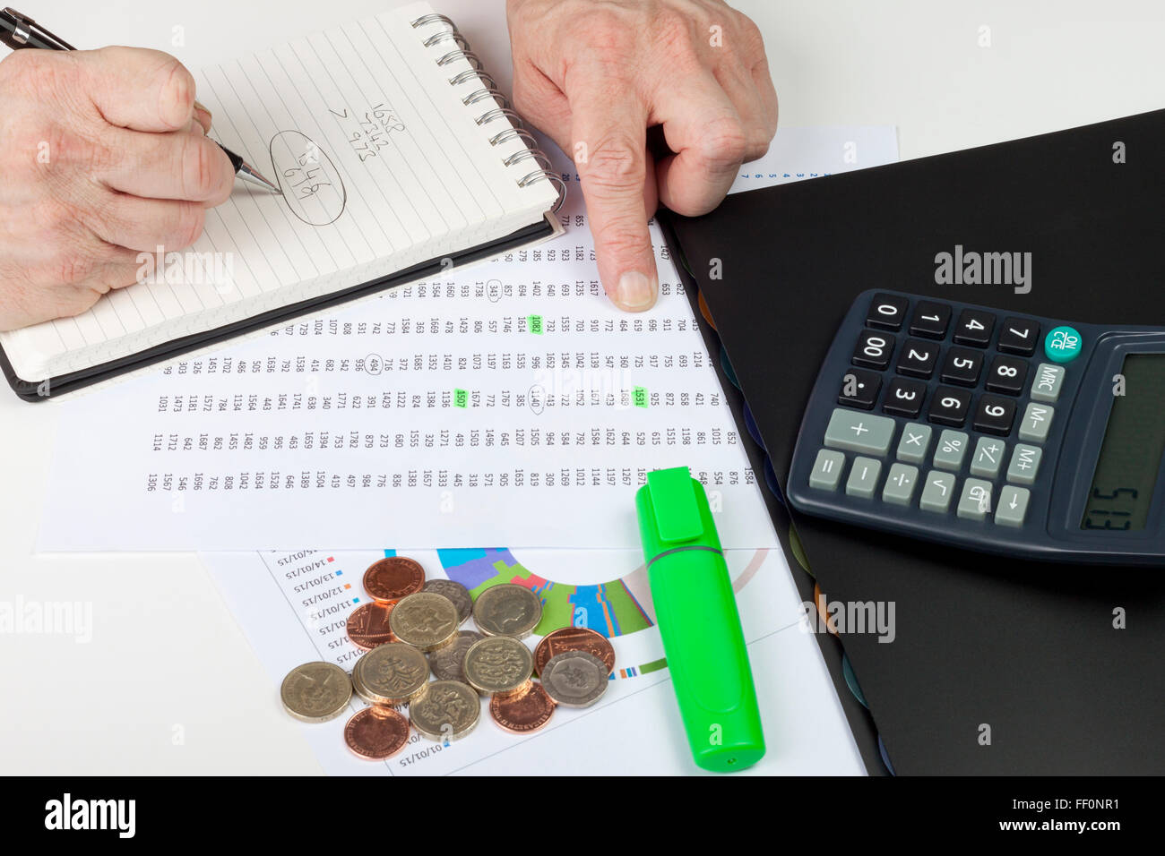 Finanzier verweisen auf eine Tabelle mit einem Taschenrechner und Notizen in seinem Editor Stockfoto
