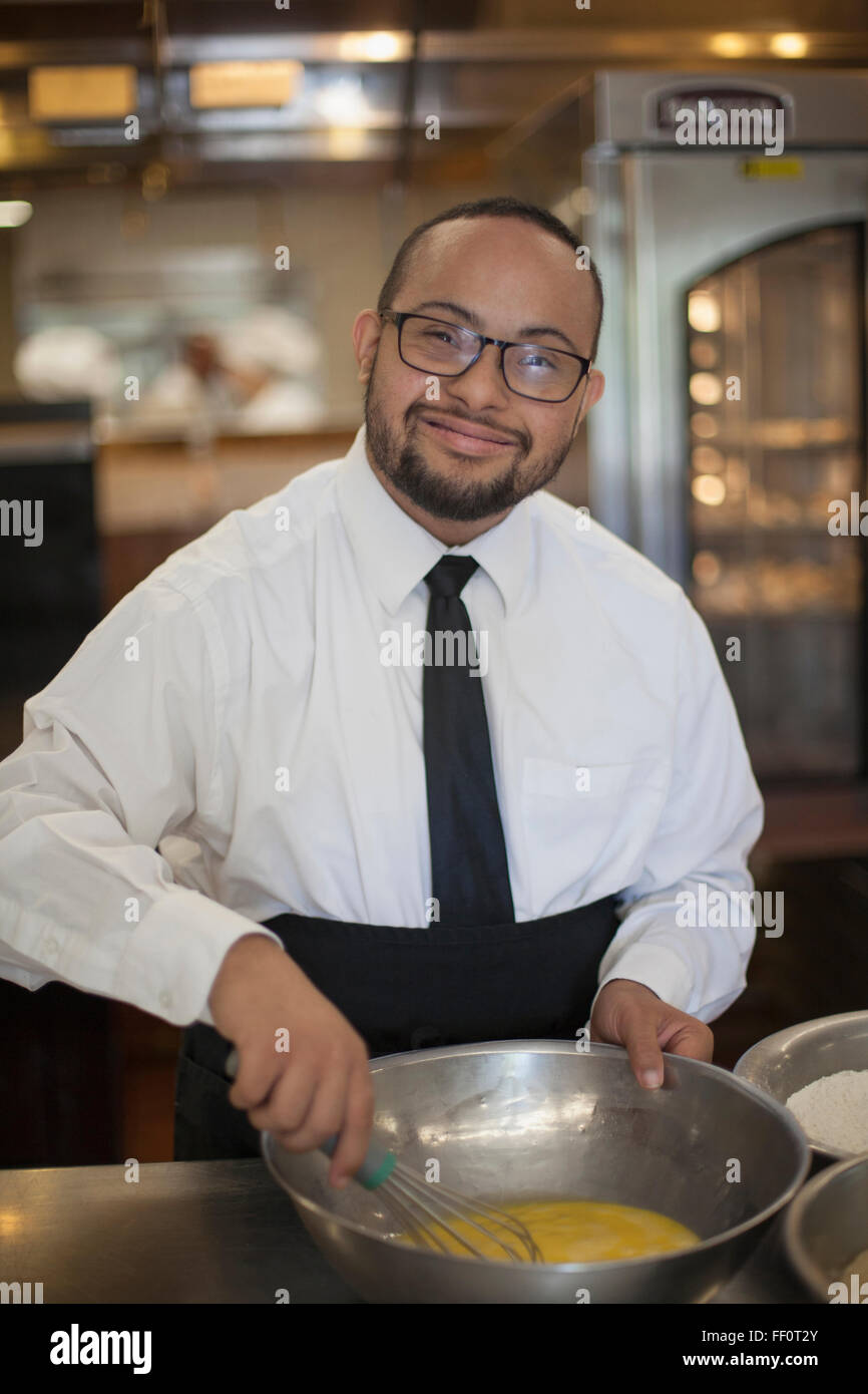 Gemischter Abstammung Koch mit Down-Syndrom im Restaurant Kochen Stockfoto