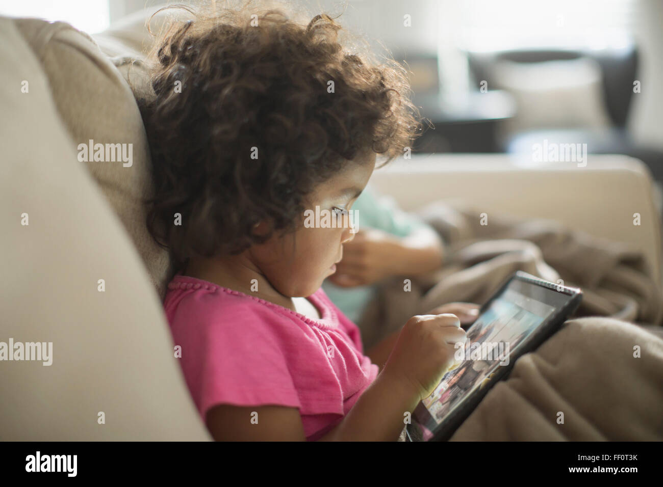 Mädchen mit digital-Tablette auf sofa Stockfoto