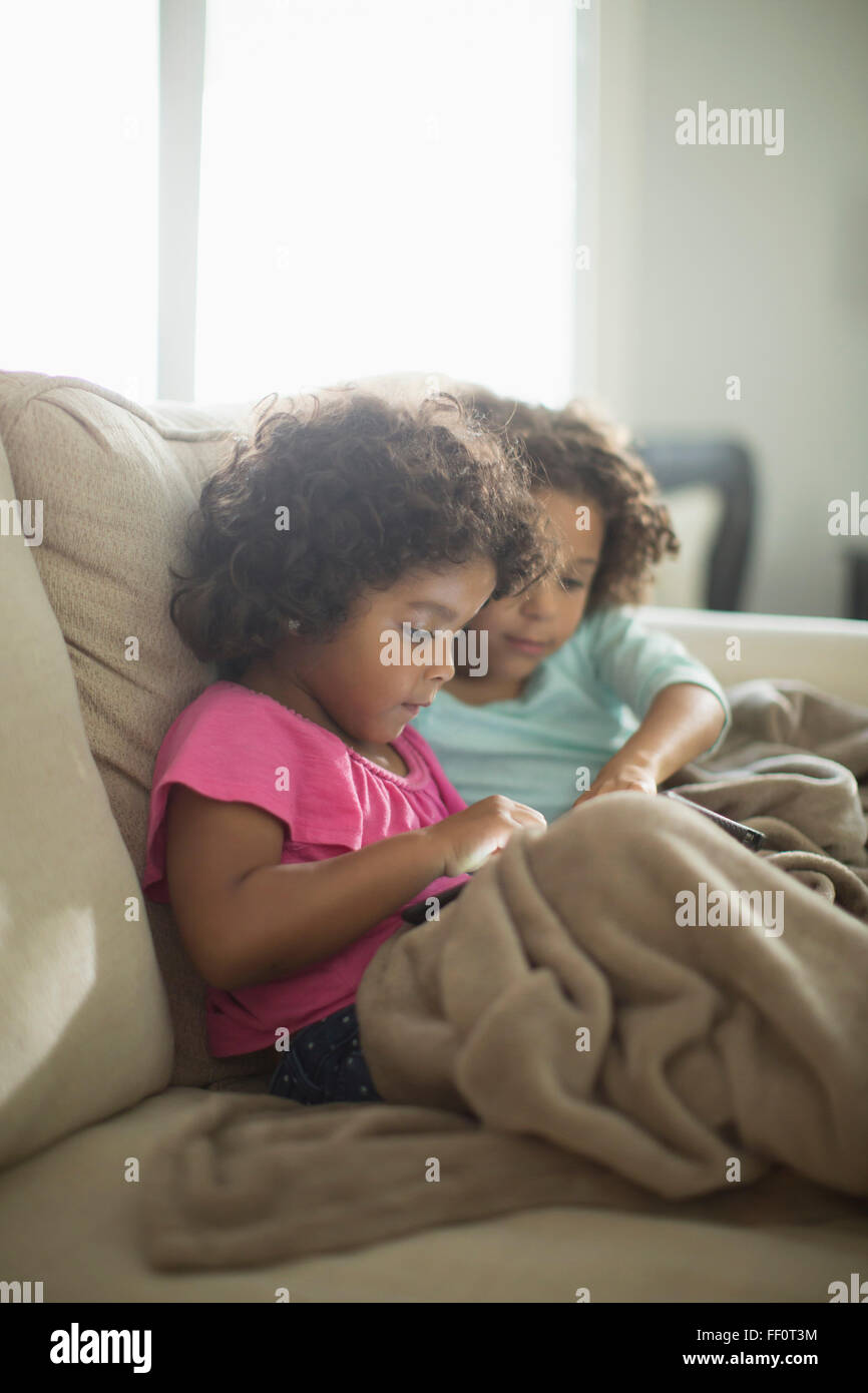 Schwestern mit digital-Tablette auf sofa Stockfoto