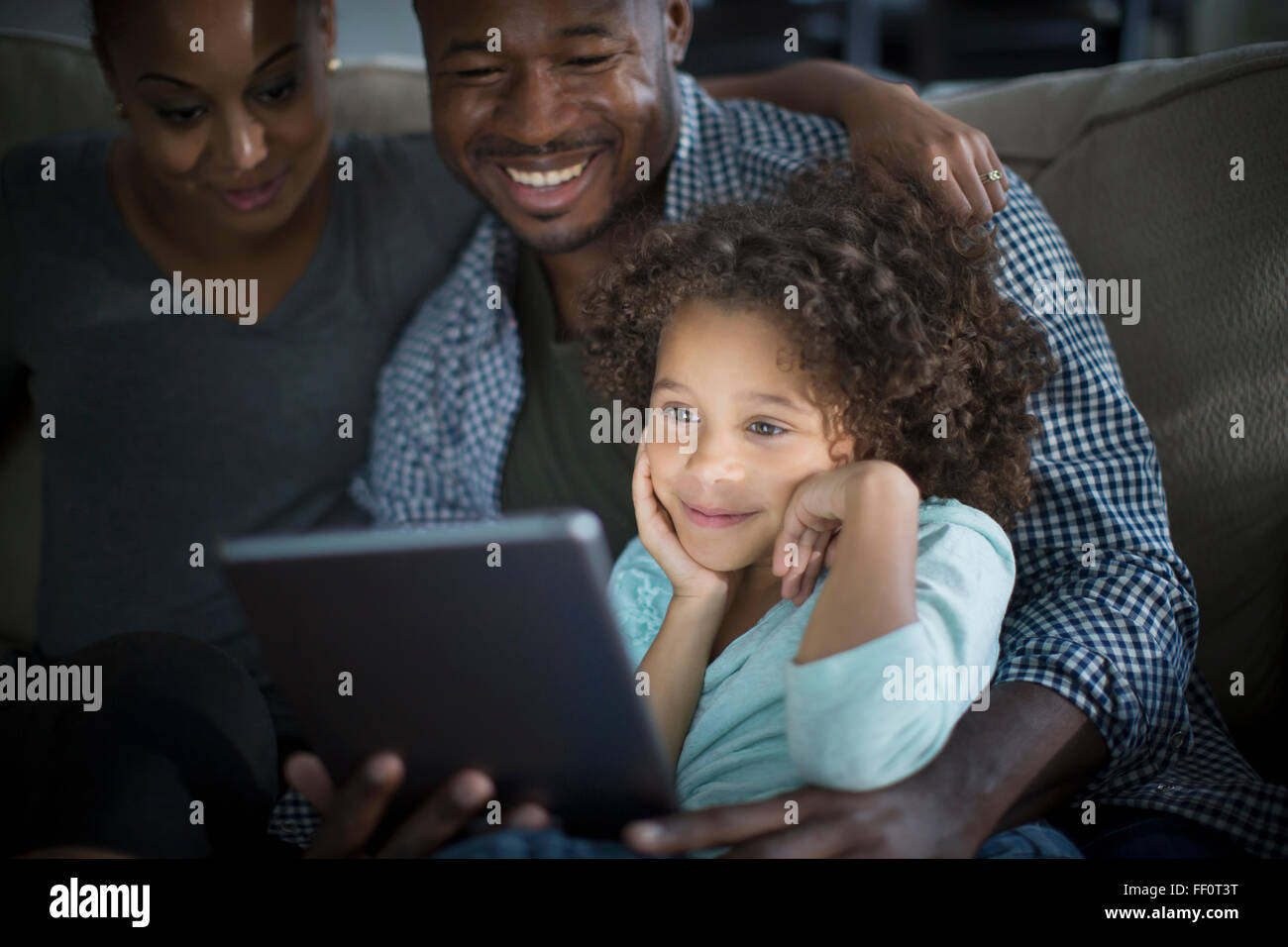 Familie mit digital-Tablette auf sofa Stockfoto