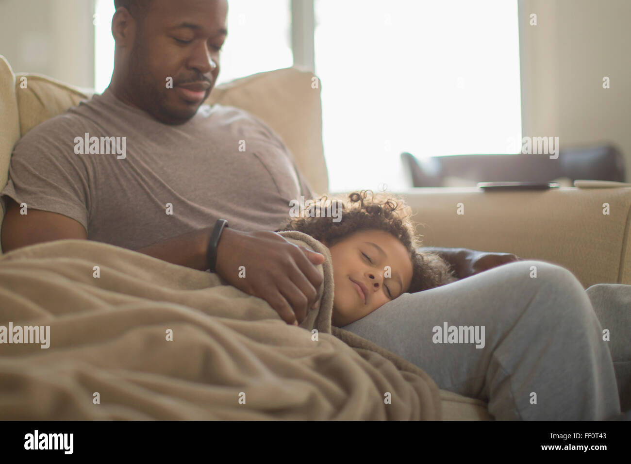 Vater und Tochter auf Sofa kuscheln Stockfoto
