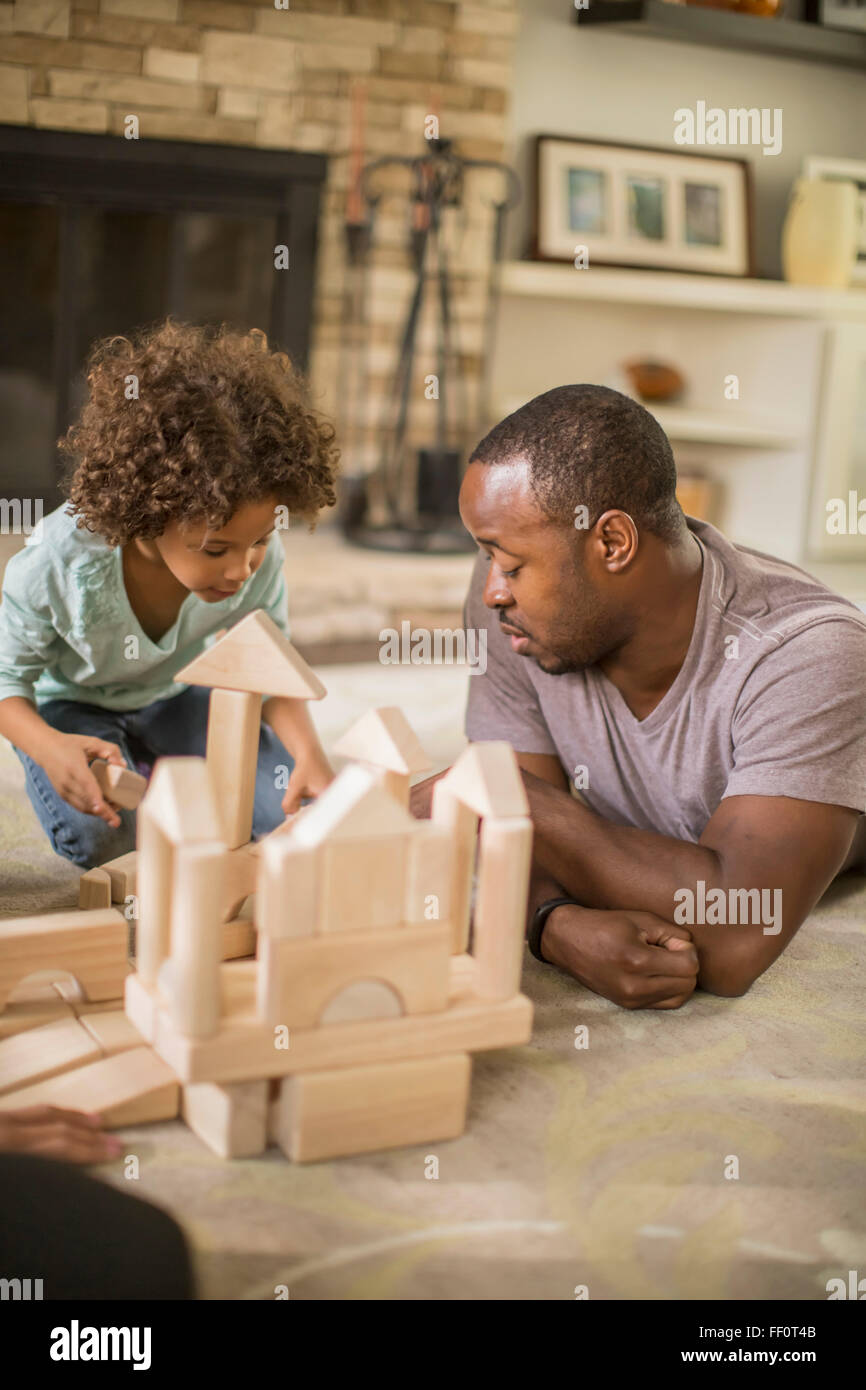 Vater und Tochter spielen mit Bausteinen im Wohnzimmer Stockfoto