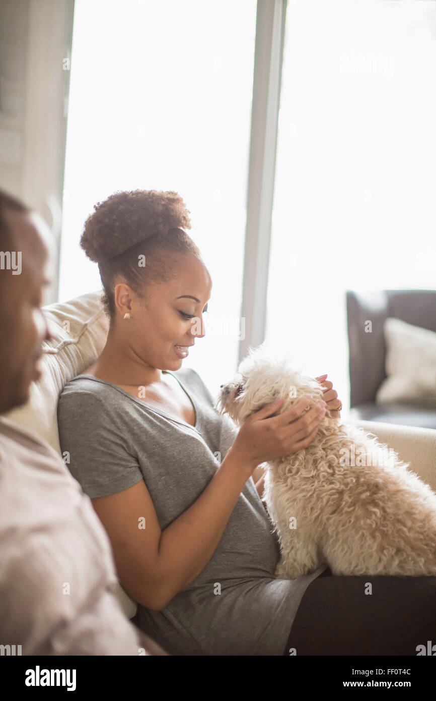 Paar Petting Hund auf sofa Stockfoto