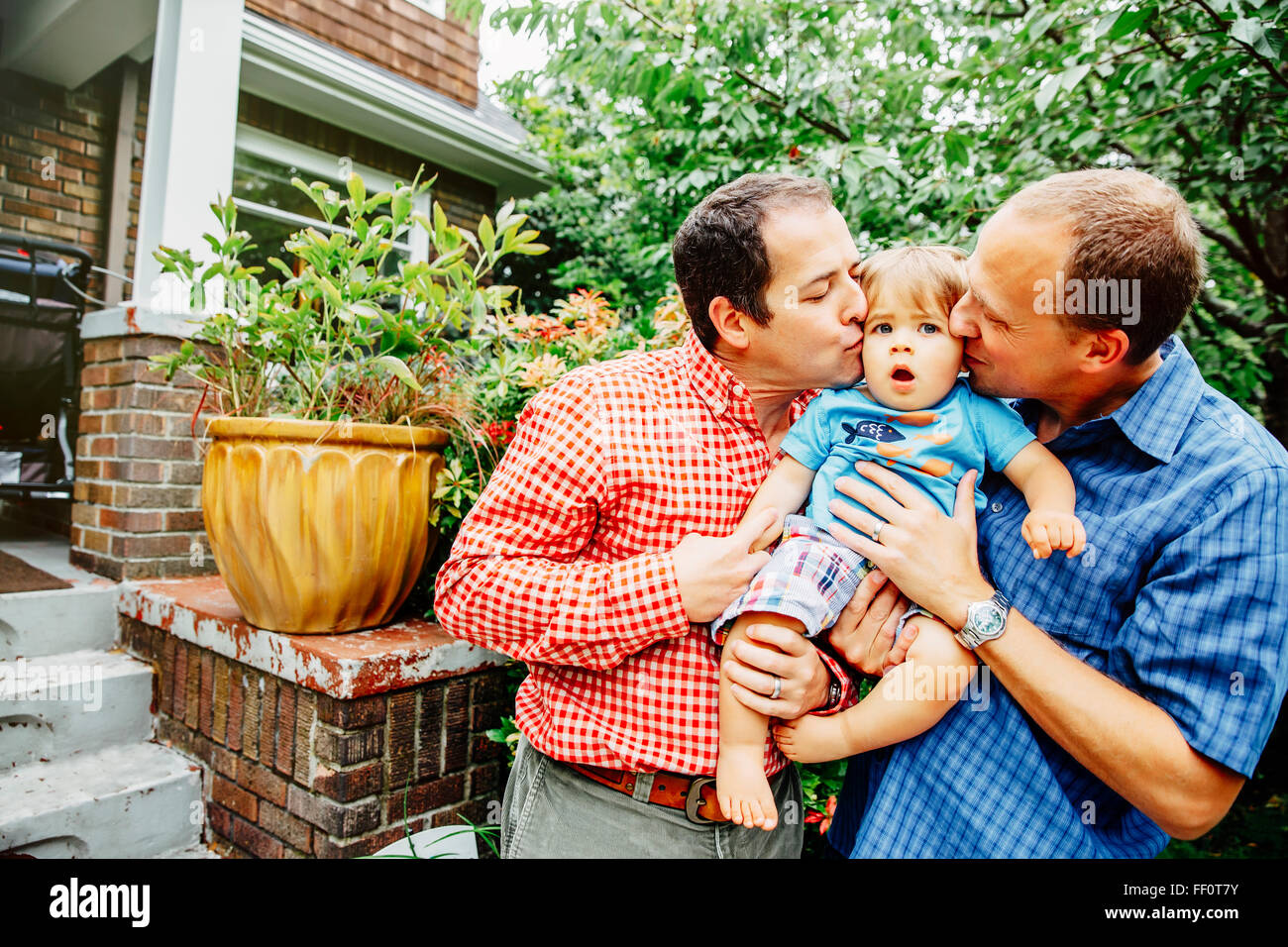 Schwule Väter küssen Baby Sohn im freien Stockfoto