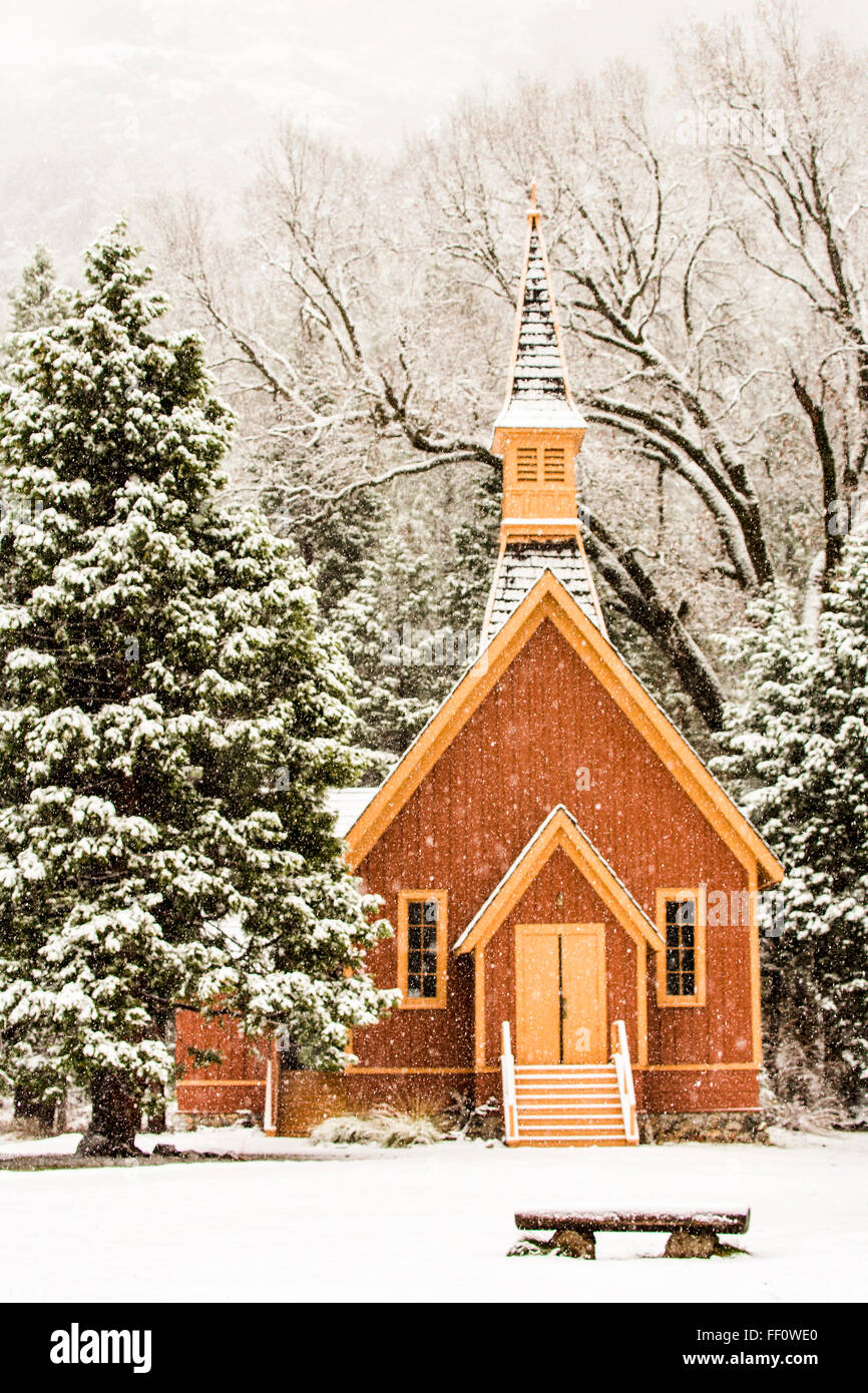 Kirche und Sitzbank in schneebedecktes Feld Stockfoto