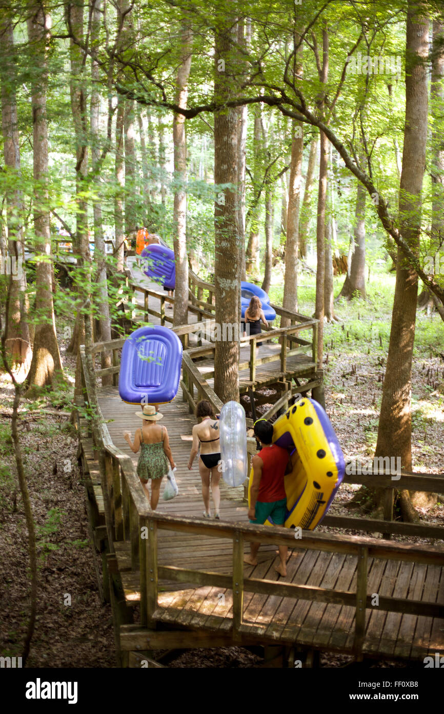 Eine Gruppe von Menschen tragen ihre Schlauchboote entlang einer Promenade in den Florida-Wald auf ihrem Weg den Fluss hinunter zu schweben. Stockfoto