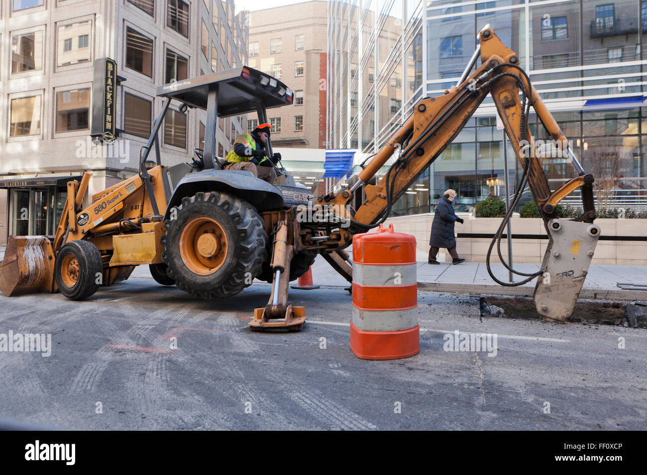 Tieflöffel mit Presslufthammer Anlage arbeiten in städtischen Fahrbahn - USA Stockfoto