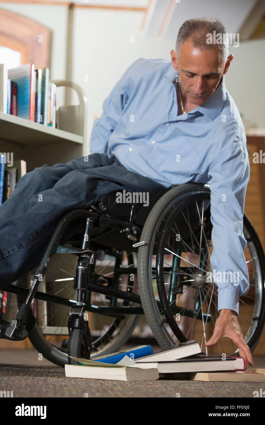 Kaukasischen Mann hob Bücher in der Bibliothek Stockfoto