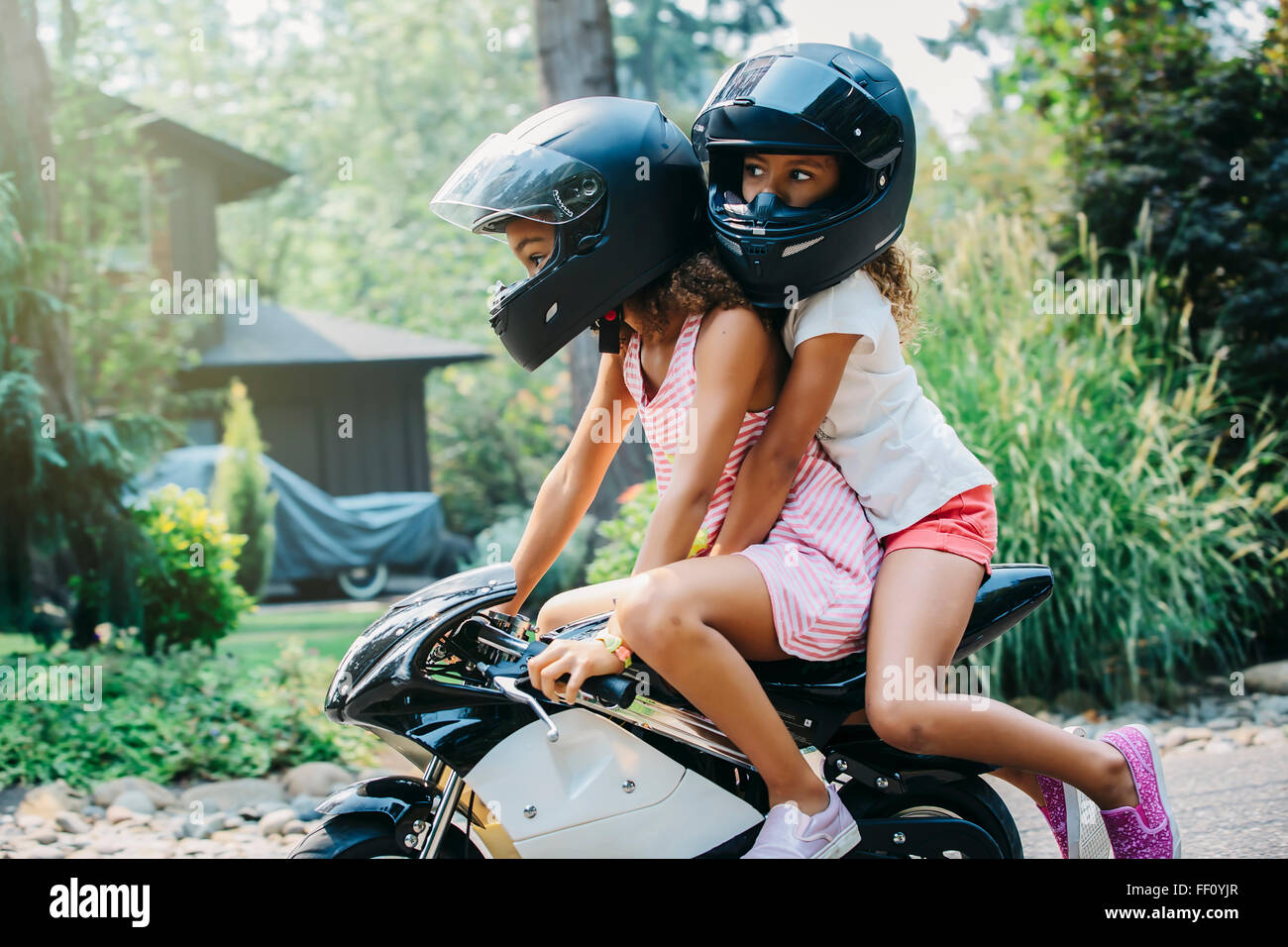 Gemischte Rassen Schwestern Miniatur Motorrad Stockfoto