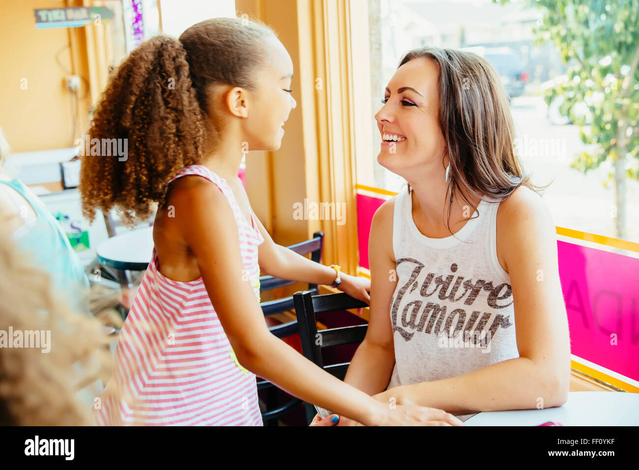 Mutter und Tochter lächelnd in café Stockfoto