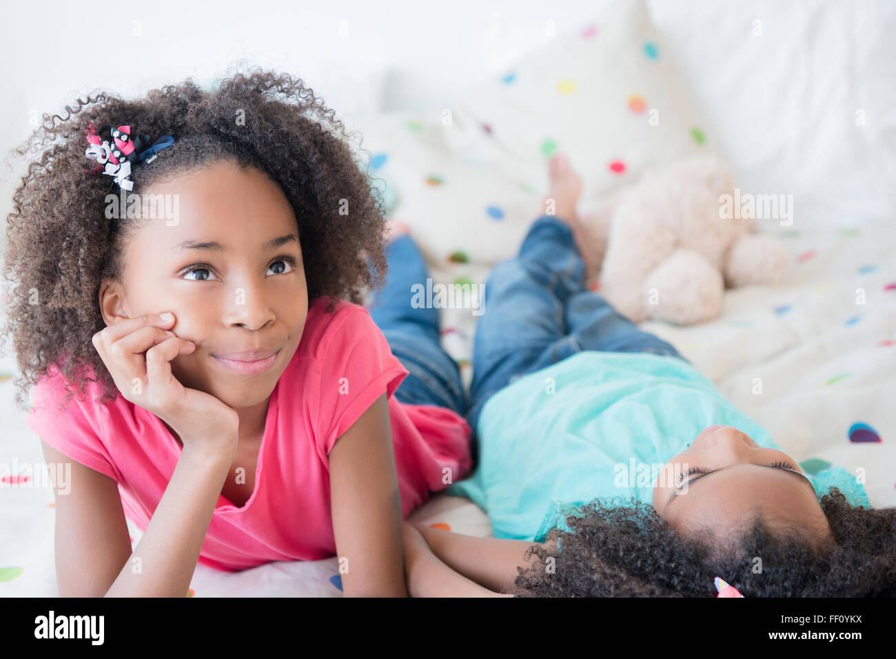 Gemischte Rassen Schwestern auf Bett Stockfoto
