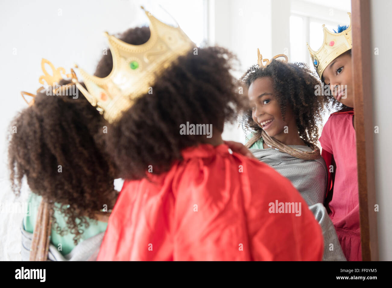 Gemischte Rassen Schwestern spielen verkleiden sich im Spiegel Stockfoto