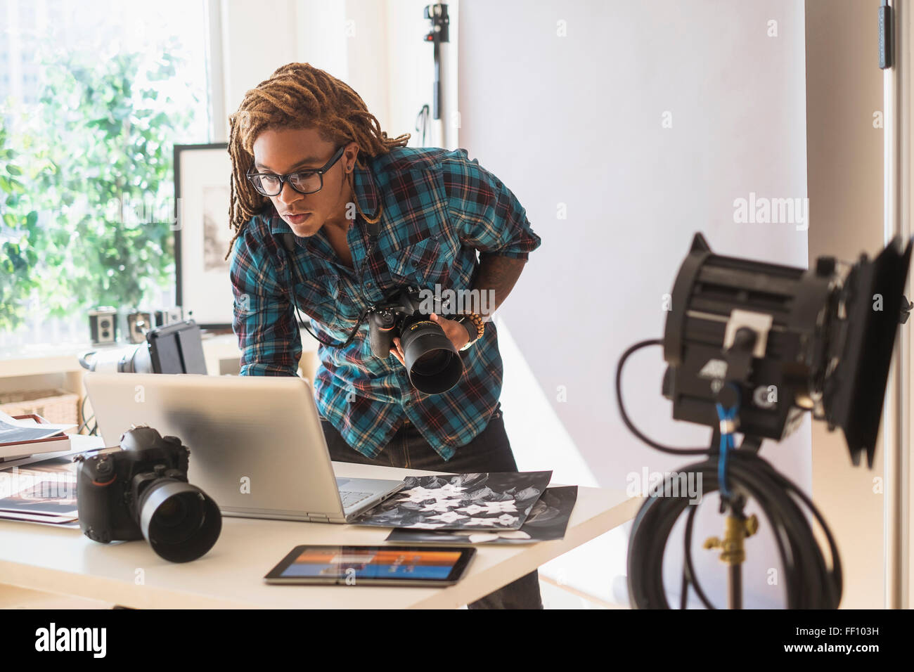 Gemischte Rassen Fotograf mit Laptop im studio Stockfoto