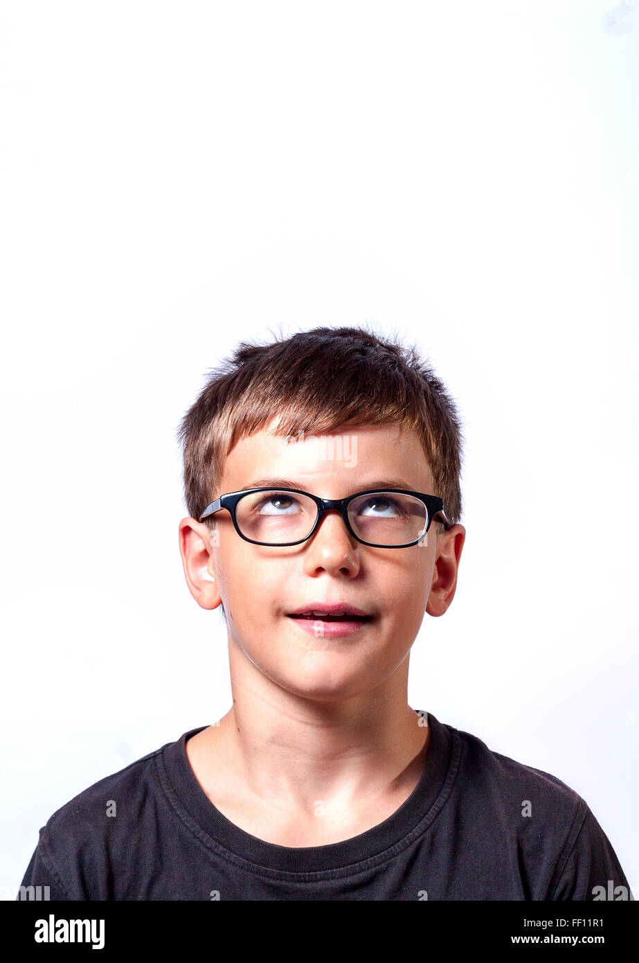 Denken Kind Portrait eines kleinen jungen Alter von 11 Jahren in Gläsern tief nachzudenken etwas nachschlagen Stockfoto