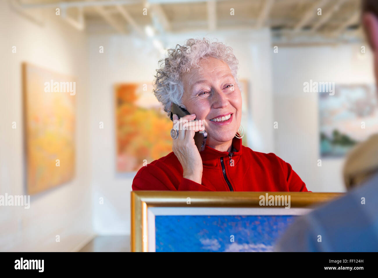 Ältere Mischlinge Frau mit Handy in der Art gallery Stockfoto