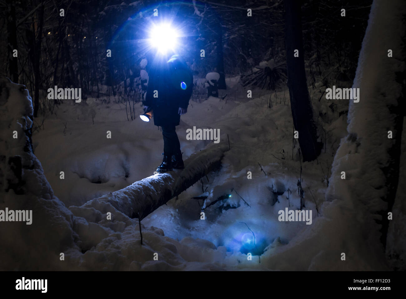Kaukasische Wanderer tragen Scheinwerfer balancieren auf Wald-log Stockfoto