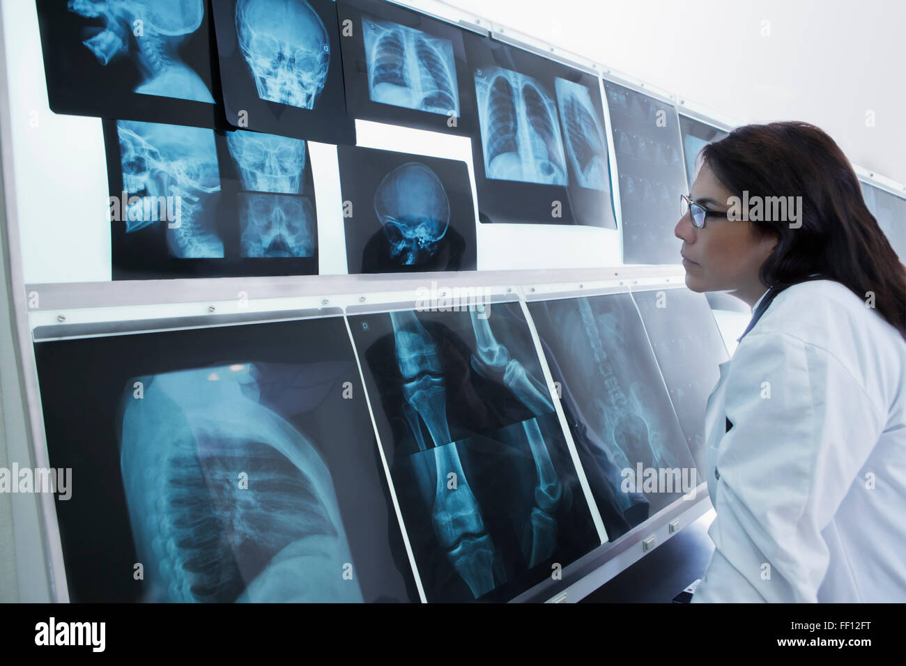 Hispanische Arzt Röntgenaufnahmen im Krankenhaus untersuchen Stockfoto