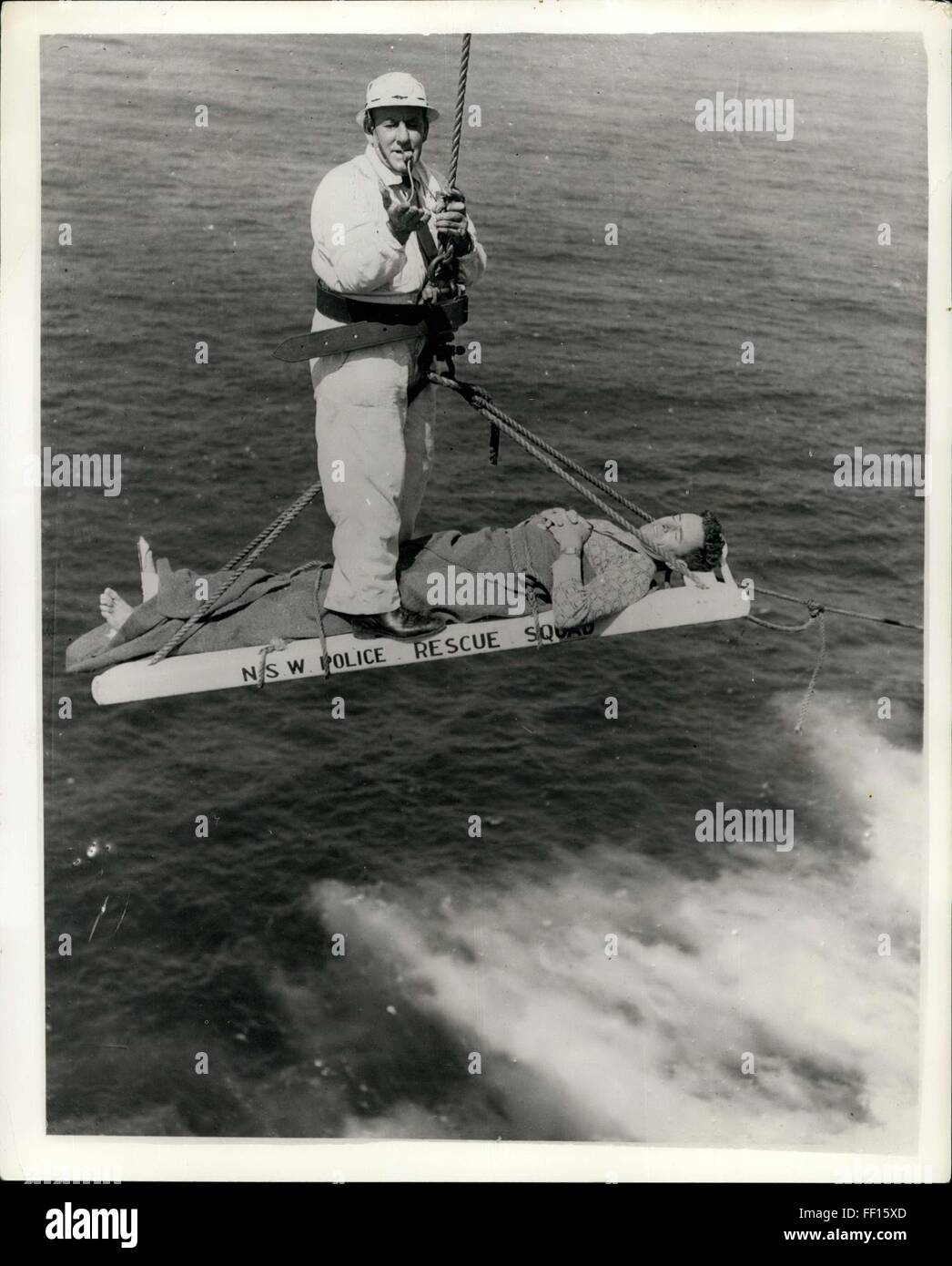 1957 - vierhundert Füße Klippe Rettung. Angler drei Stunden der Qual auf Felsvorsprung. Sgt. Harry Ware von New South Wales Police Rescue Squad-verwendet eine Pfeife als ein Signal - während dem Hissen der Fischer William Waterer an die Spitze einer 400 ft Klippe am North Head, n.s.w. Waterer (36) hatte in einer Felsspalte beim Angeln-von einer riesigen Welle-die Bein geschnappt gewaschen worden. Er lag in Agonie auf einem schmalen Sims 400 ft unterhalb blauen Fisch, Männlich, bevor die Rettung Mannschaften ihre komplexe Geräte für die gefährliche Rettung behoben bekommen konnte. © Keystone Bilder USA/ZUMAPRESS.com/Alamy Live-Nachrichten Stockfoto