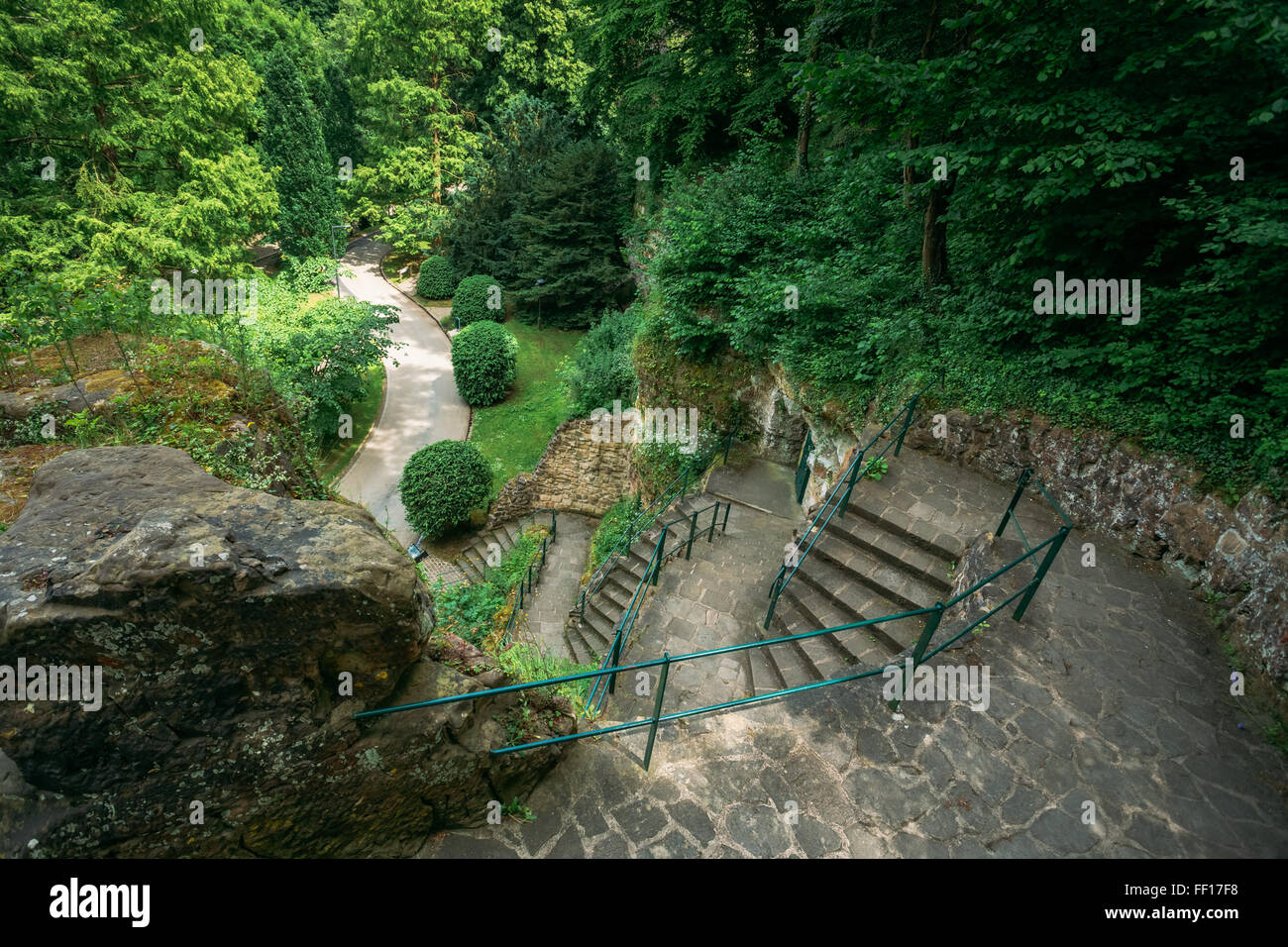 Pathway Gehweg Lane Pflasterweg mit grünen Bäumen und Büschen im Park. Schöne Gasse im Sommerpark Stockfoto