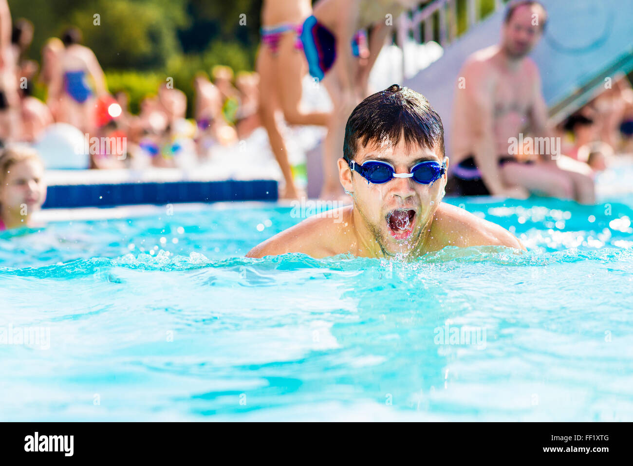 Mann mit Brille Swimmning im Pool. Sommerliche Hitze, Wasser. Stockfoto