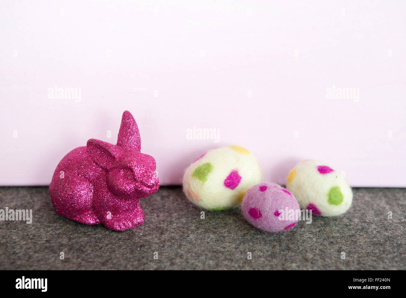 lila Osterhase mit Ostereiern und rosa Hintergrund Stockfoto