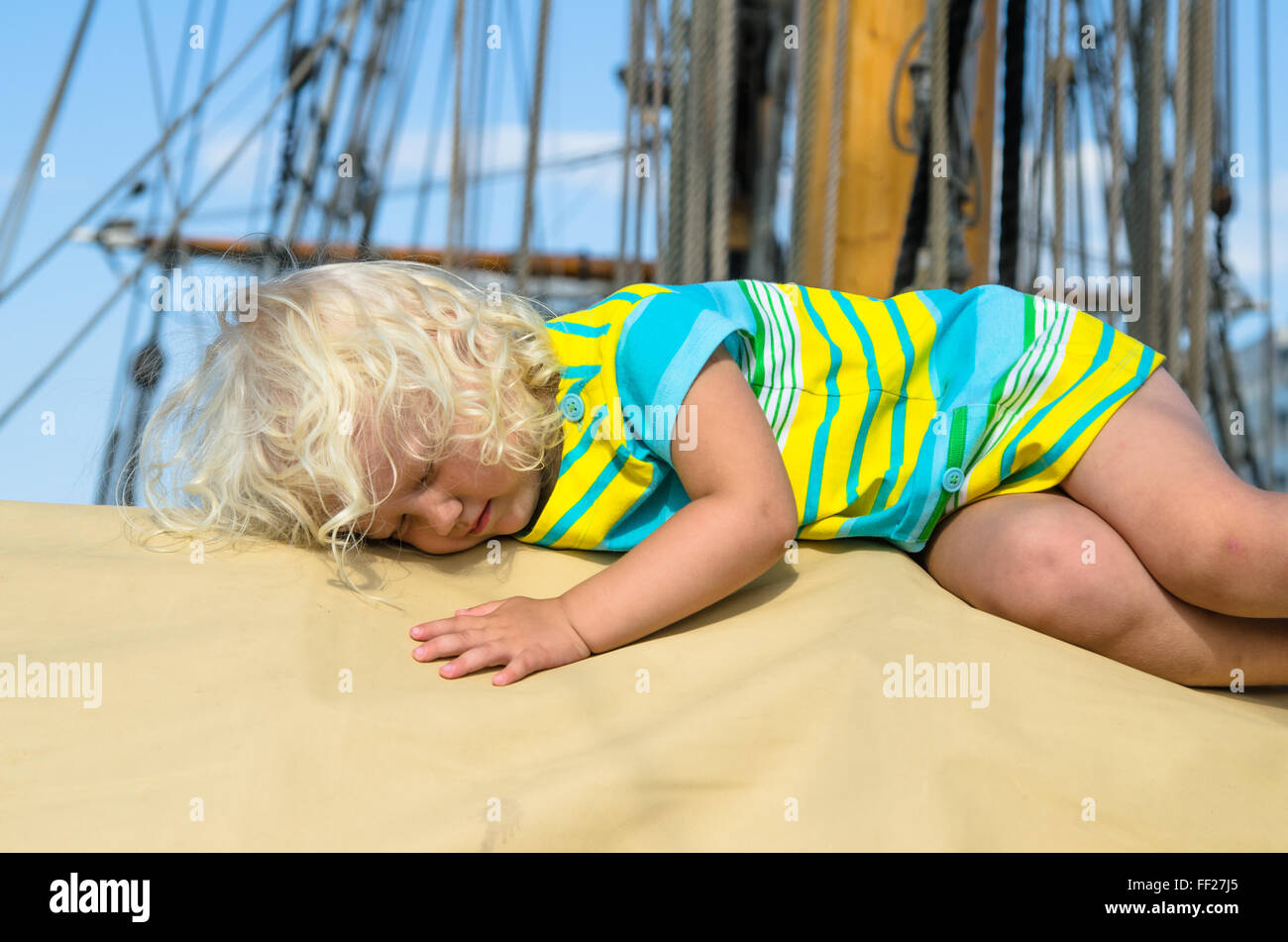 Das kleine Mädchen schlief auf dem Deck eines Segelbootes Stockfoto