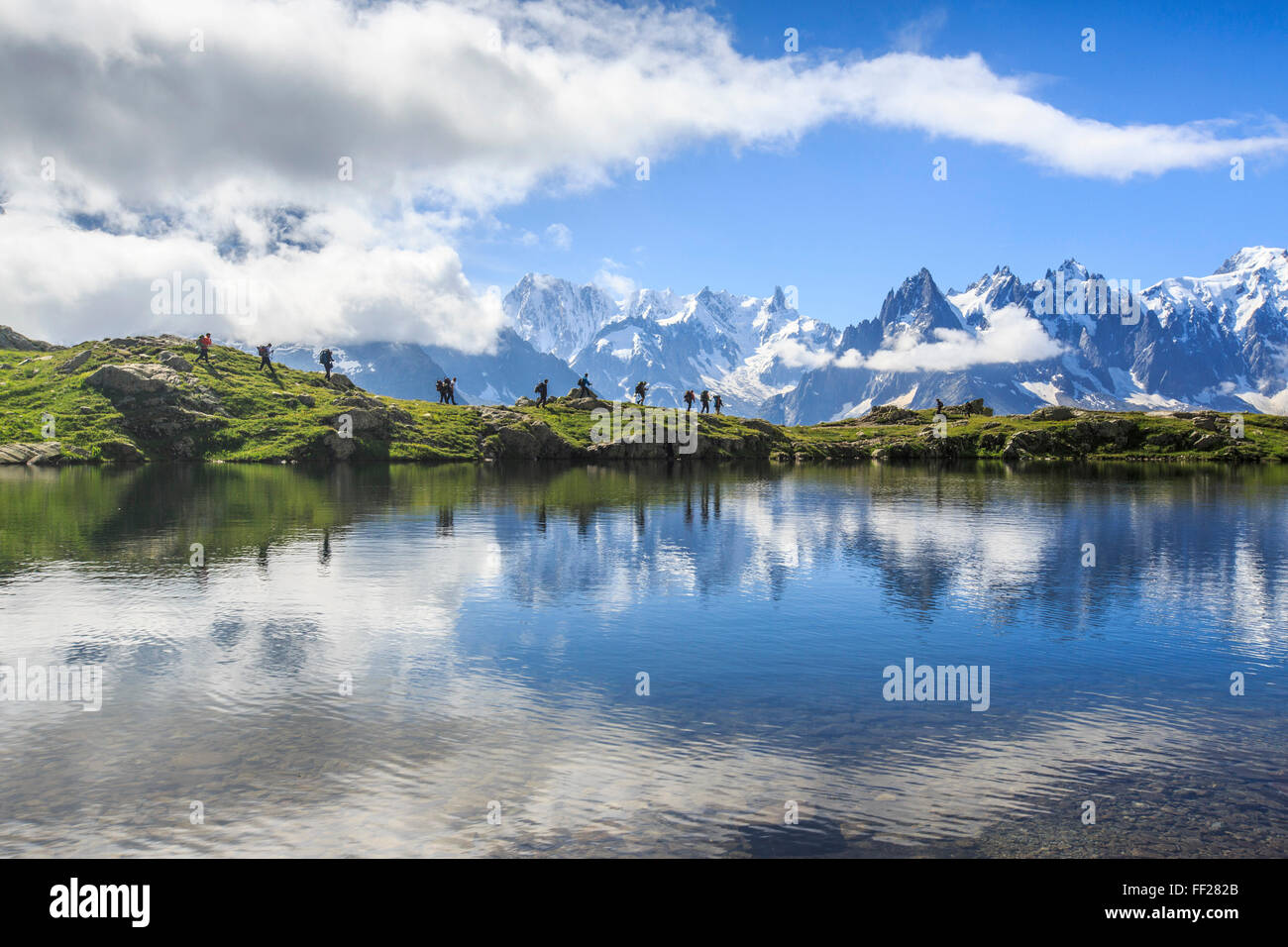 Niedrige Wolken und Nebel um Grandes Jorasses und Mont-Blanc, während Wanderer am Lac De Cheserys, Haute Savoie, französischen Alpen gehen Stockfoto