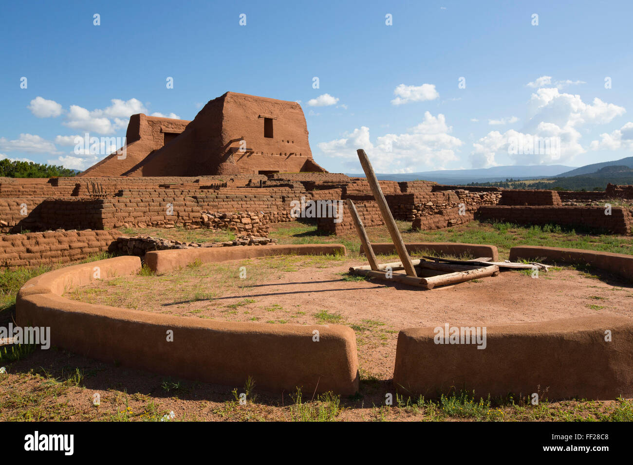PuebRMo Mission im Hintergrund), Kiva im Vordergrund, Pecos NationaRM Historic Park, New Mexico, Vereinigte Staaten von Amerika Stockfoto