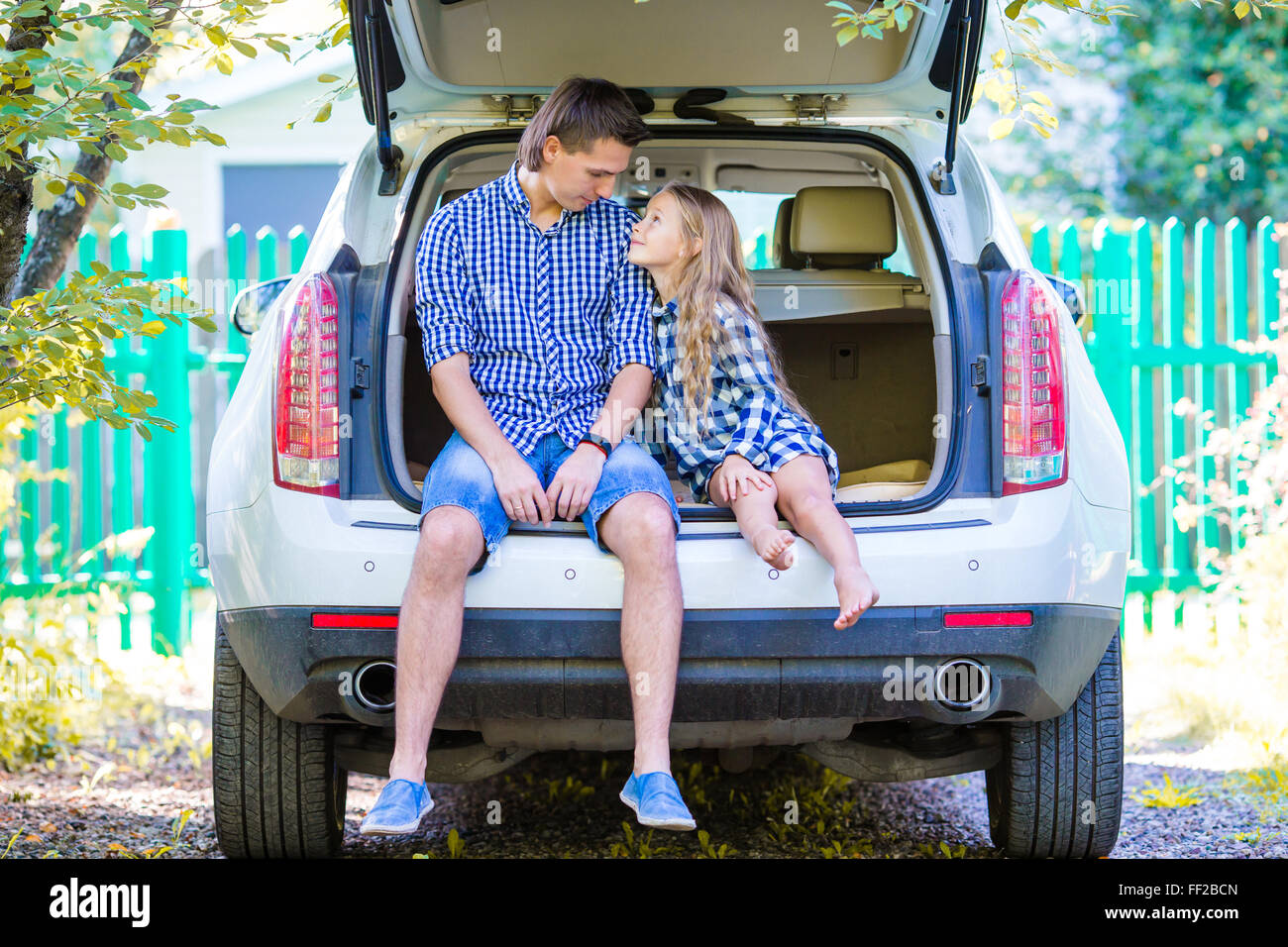 Kleines Mädchen mit Papa kurz vor der Abreise für einen Auto-Urlaub in einem Auto sitzen Stockfoto