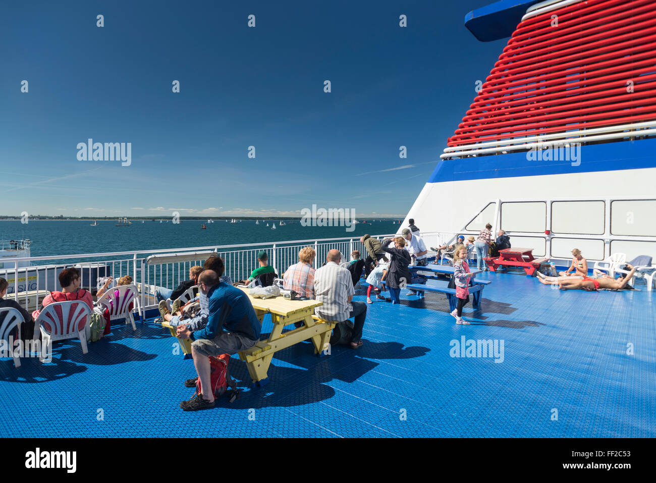 Passagiere, die zum Sonnenbaden an Deck der Fähre von Rostock nach Schweden an der deutschen Küste in Warnemünde suchen Stockfoto