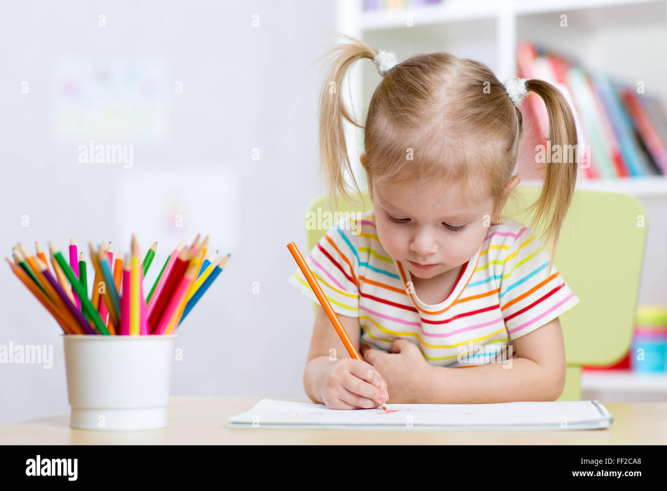 Kind Mädchen zeichnen mit bunten Stiften in Kindergarten Stockfoto